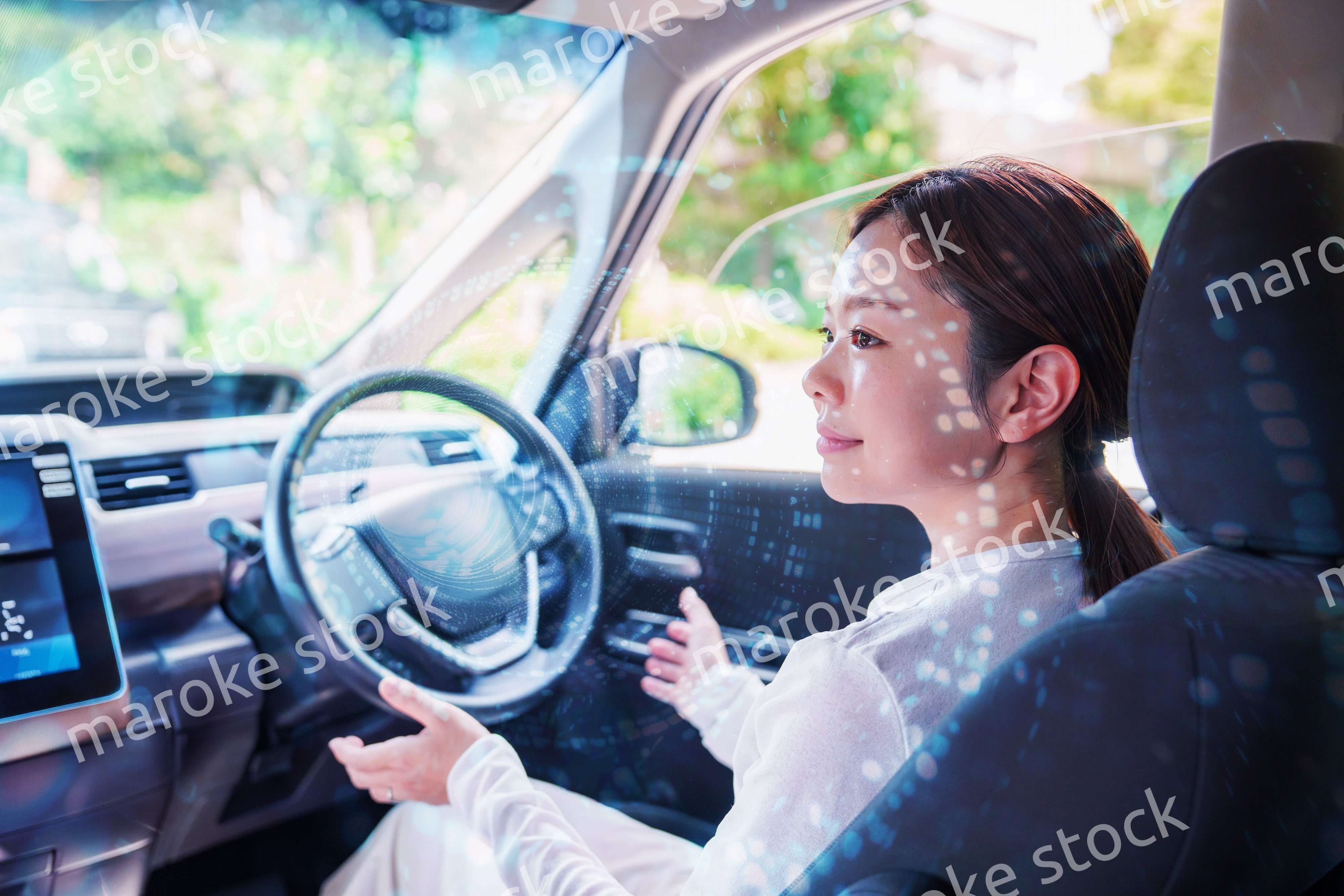 自動運転の車を運転する若い女性