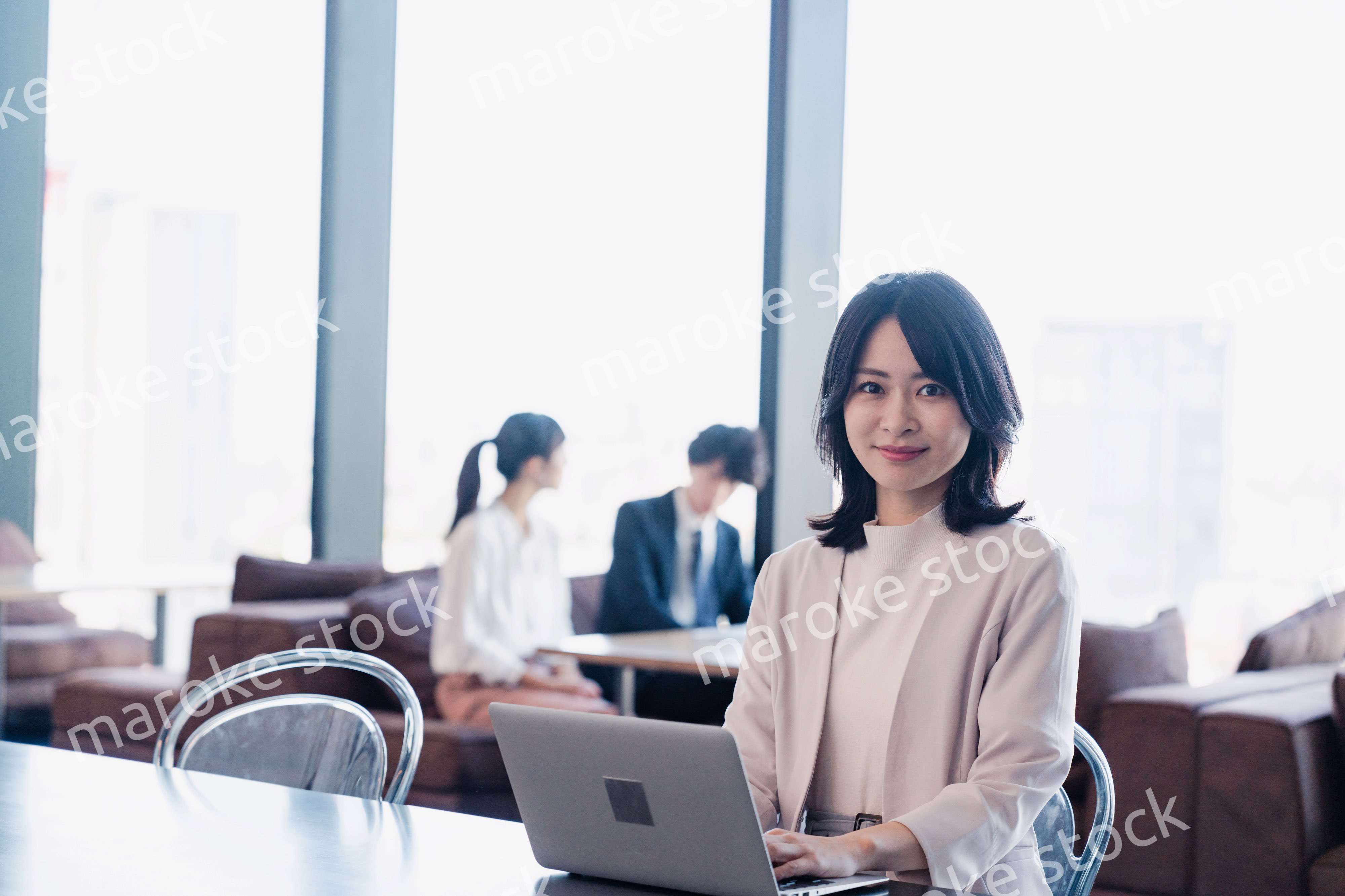 シェアオフィスでノートパソコンを使うビジネスウーマン