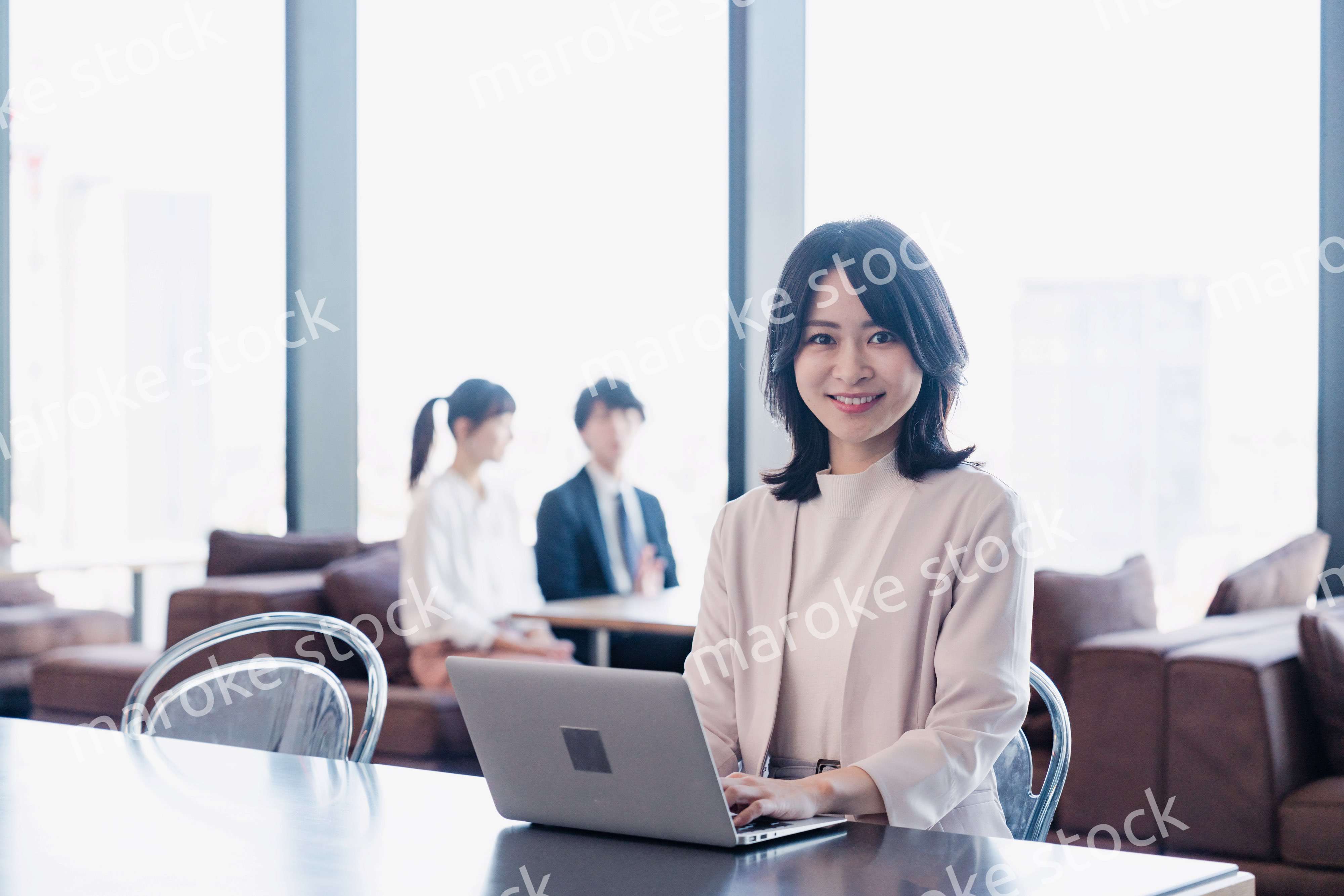 シェアオフィスでノートパソコンを使うビジネスウーマン