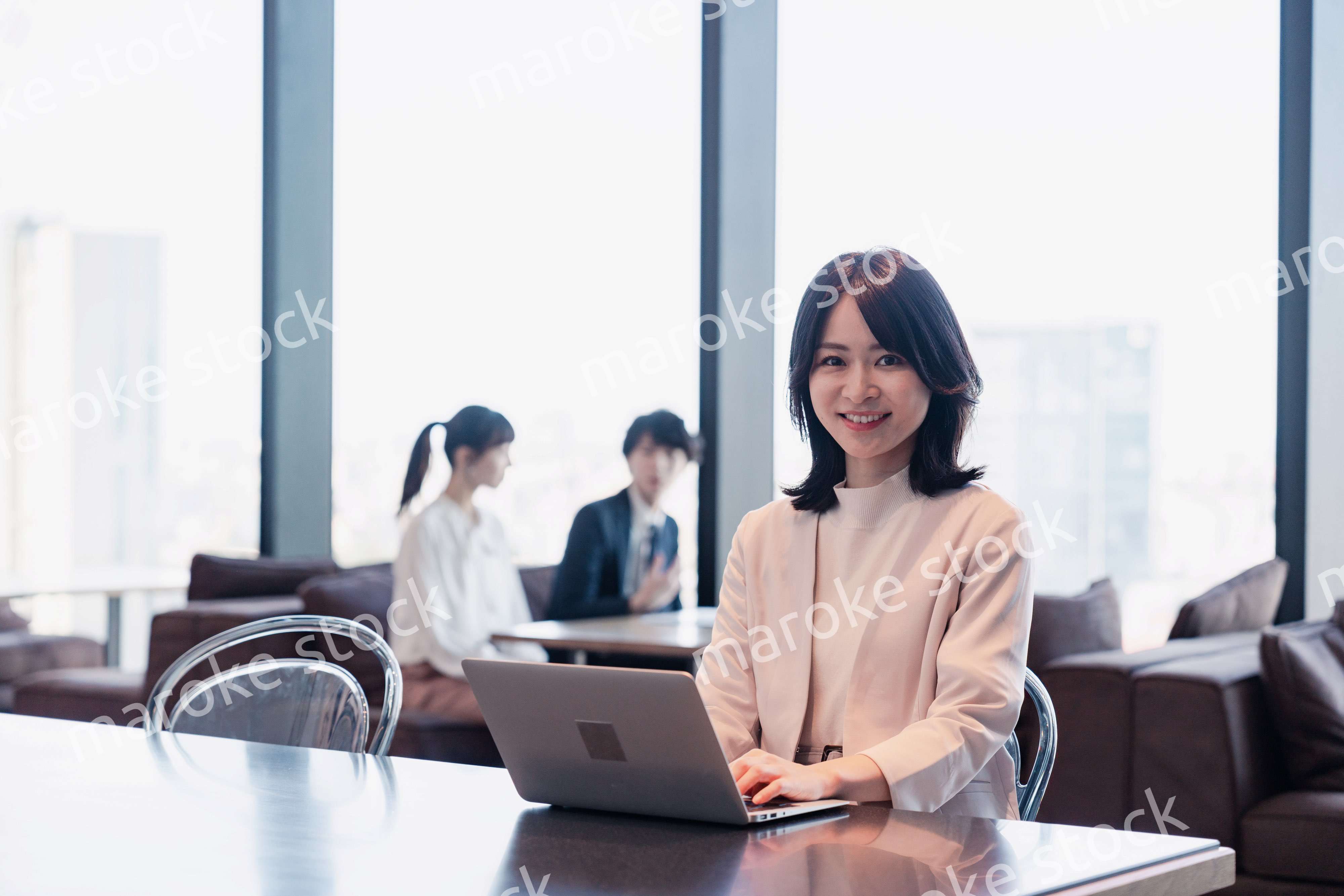 シェアオフィスでノートパソコンを使うビジネスウーマン