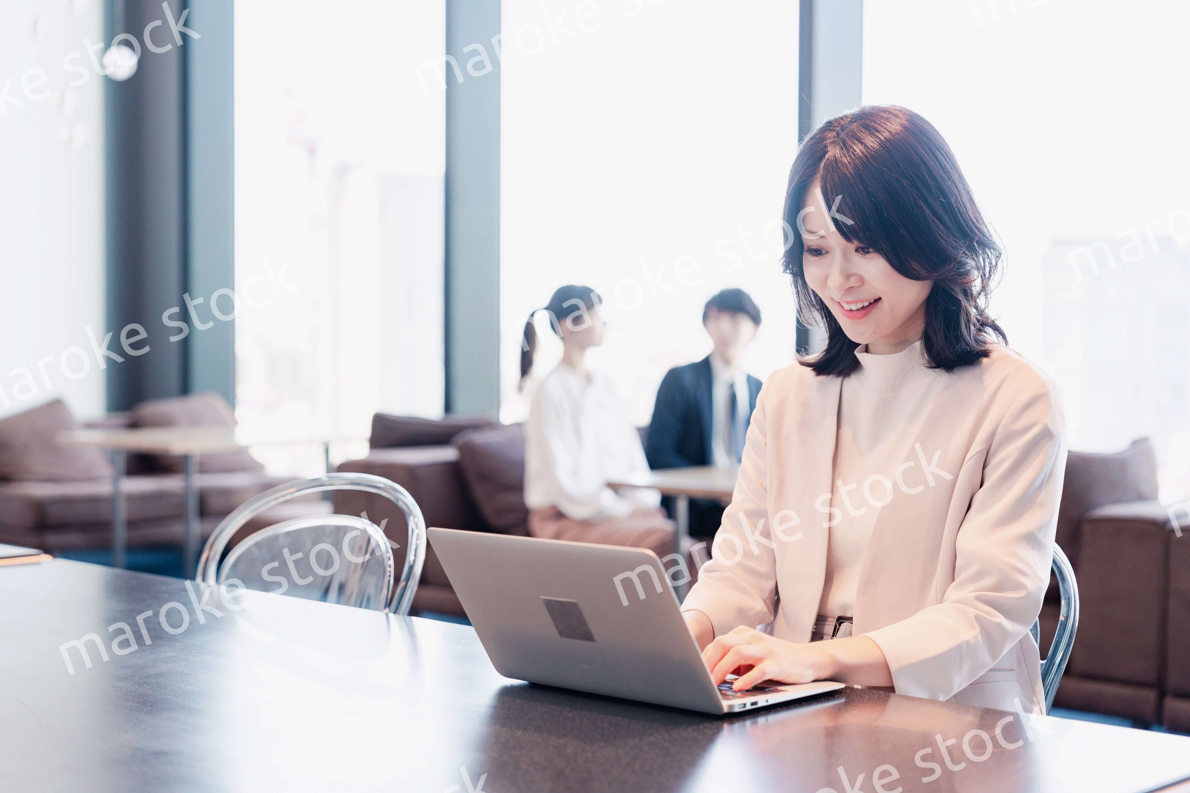 シェアオフィスでノートパソコンを使うビジネスウーマン