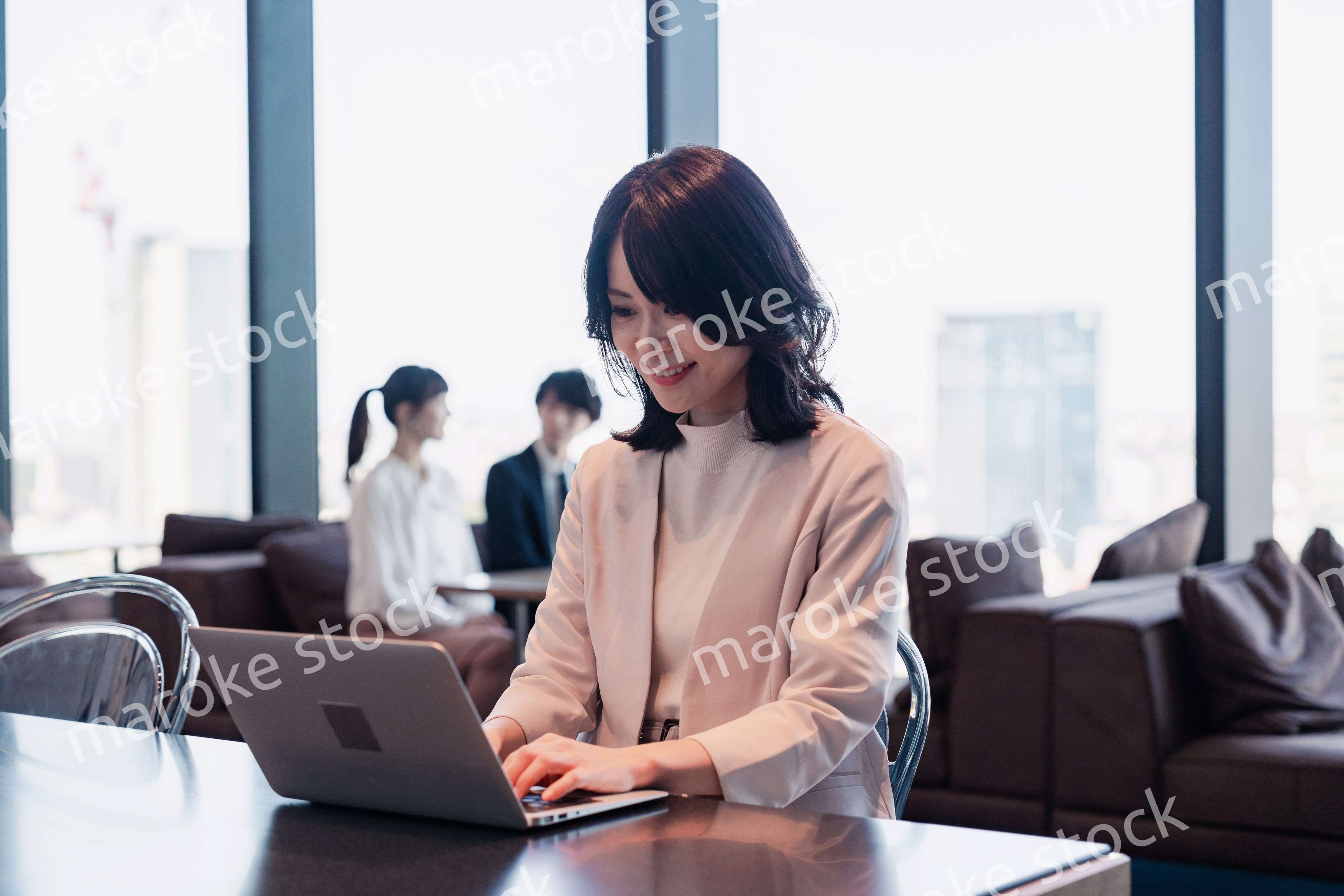 シェアオフィスでノートパソコンを使うビジネスウーマン