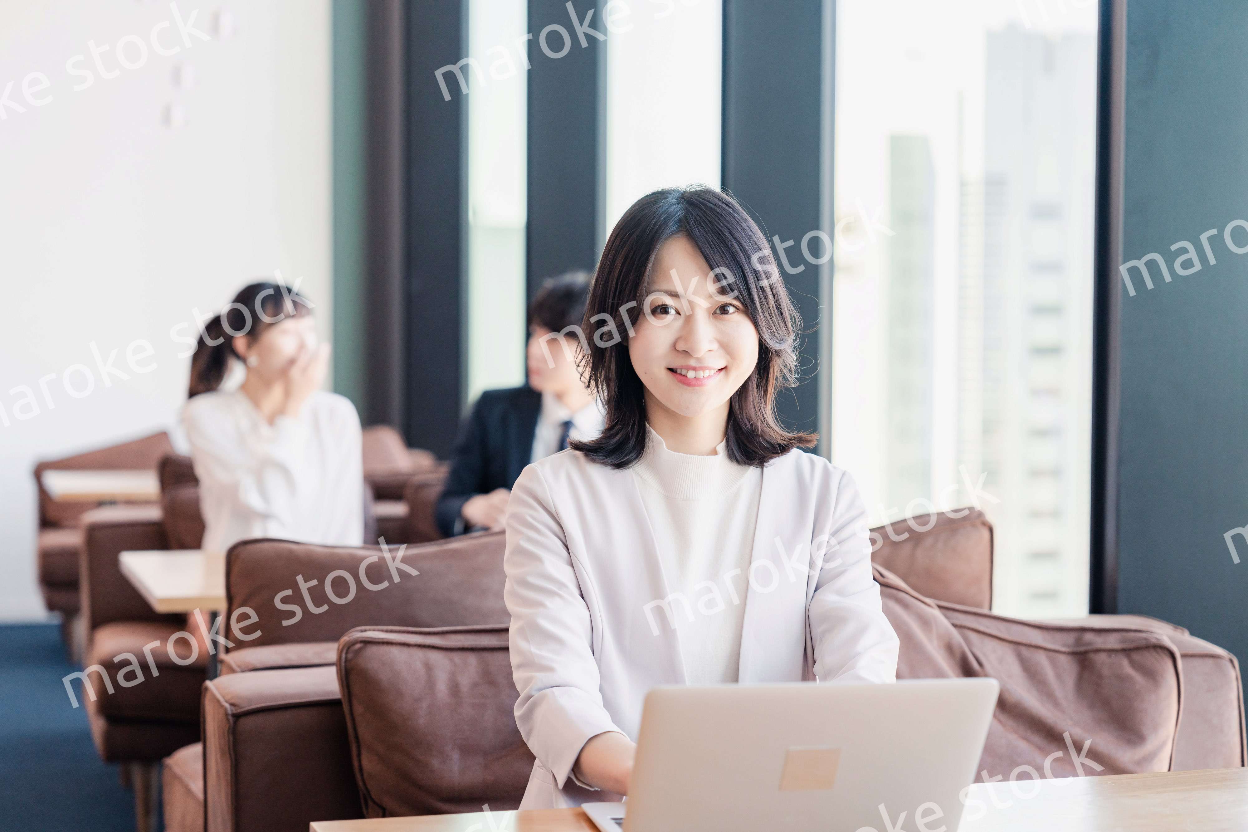 シェアオフィスでノートパソコンを使うビジネスウーマン