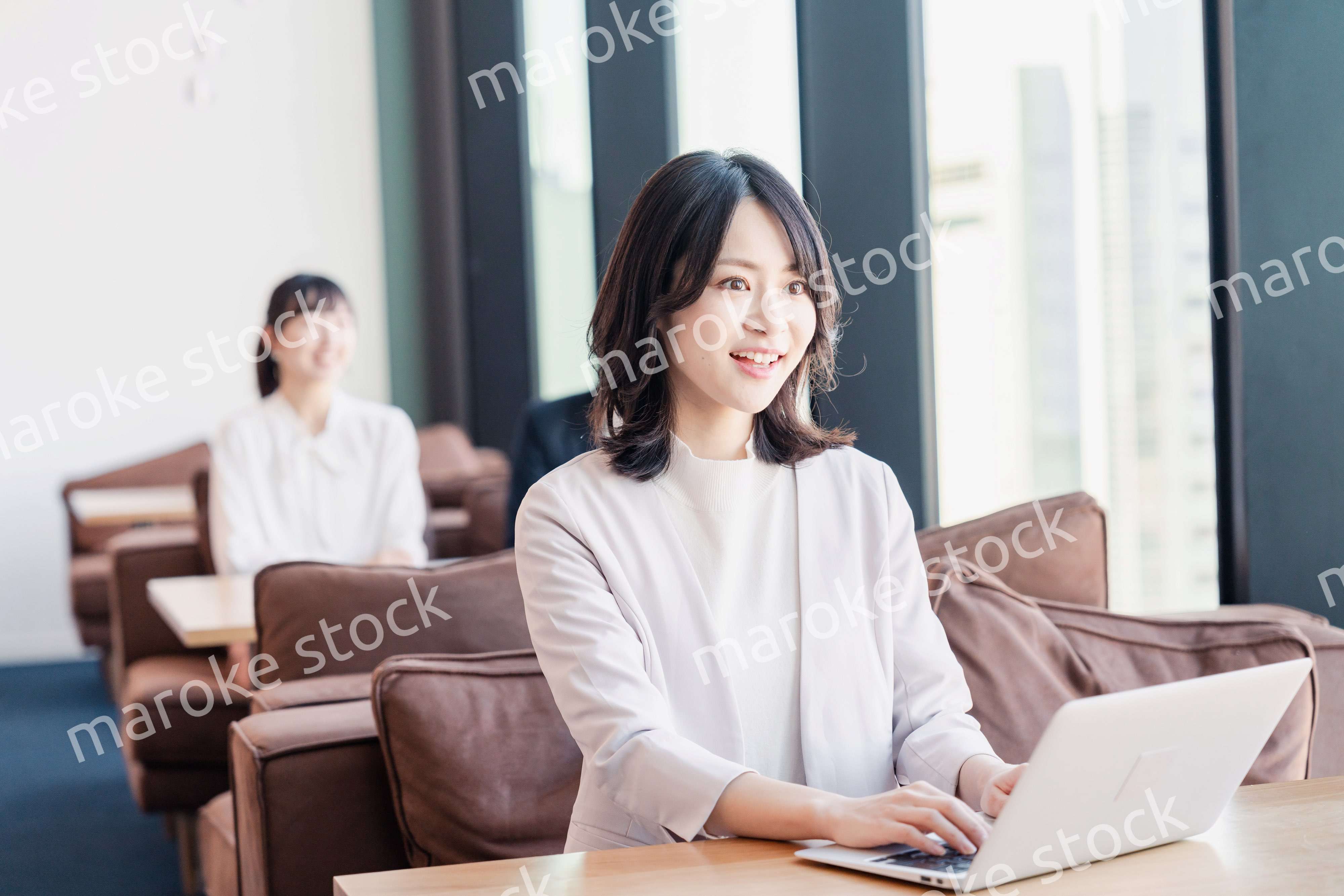 シェアオフィスでノートパソコンを使うビジネスウーマン