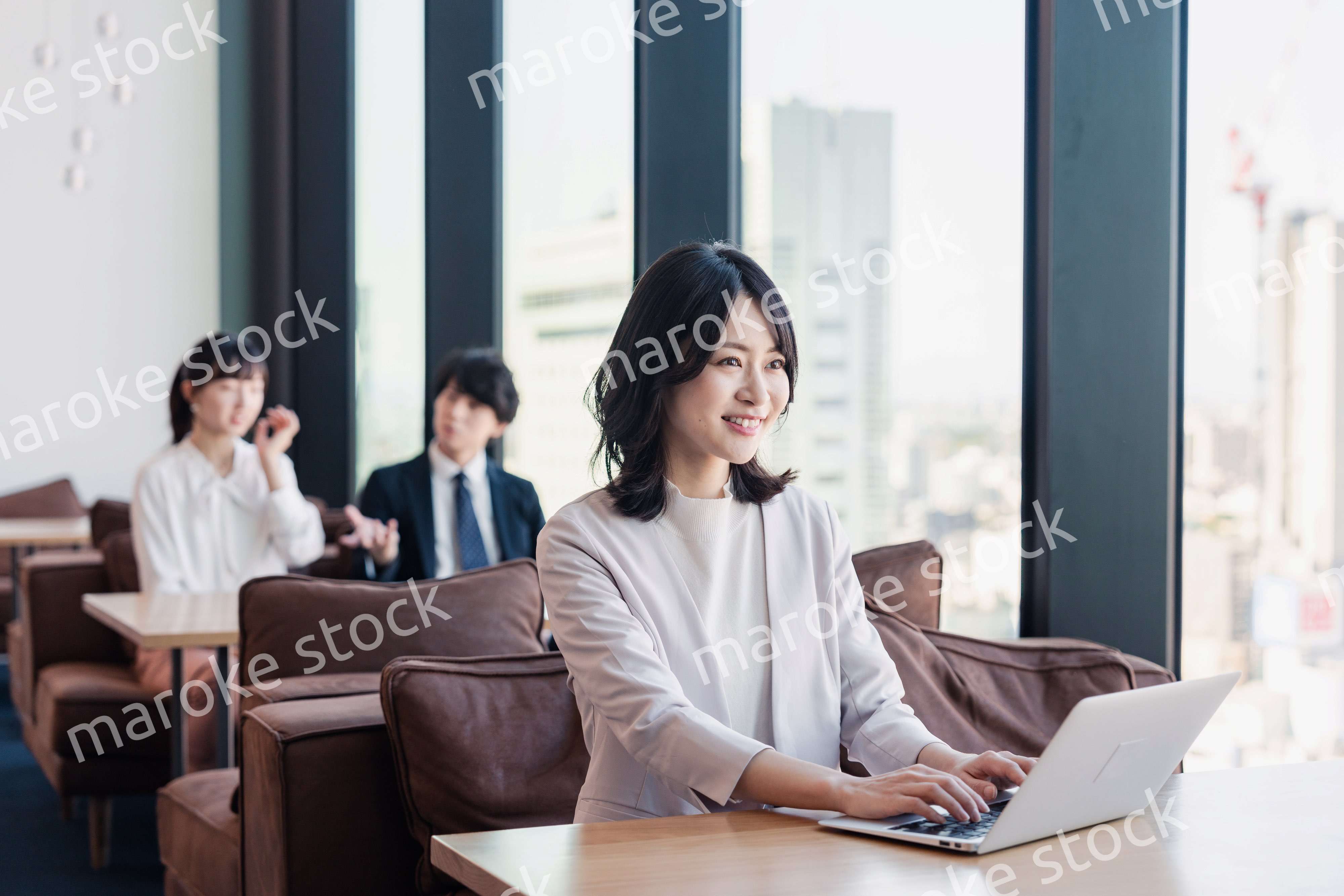 シェアオフィスでノートパソコンを使うビジネスウーマン