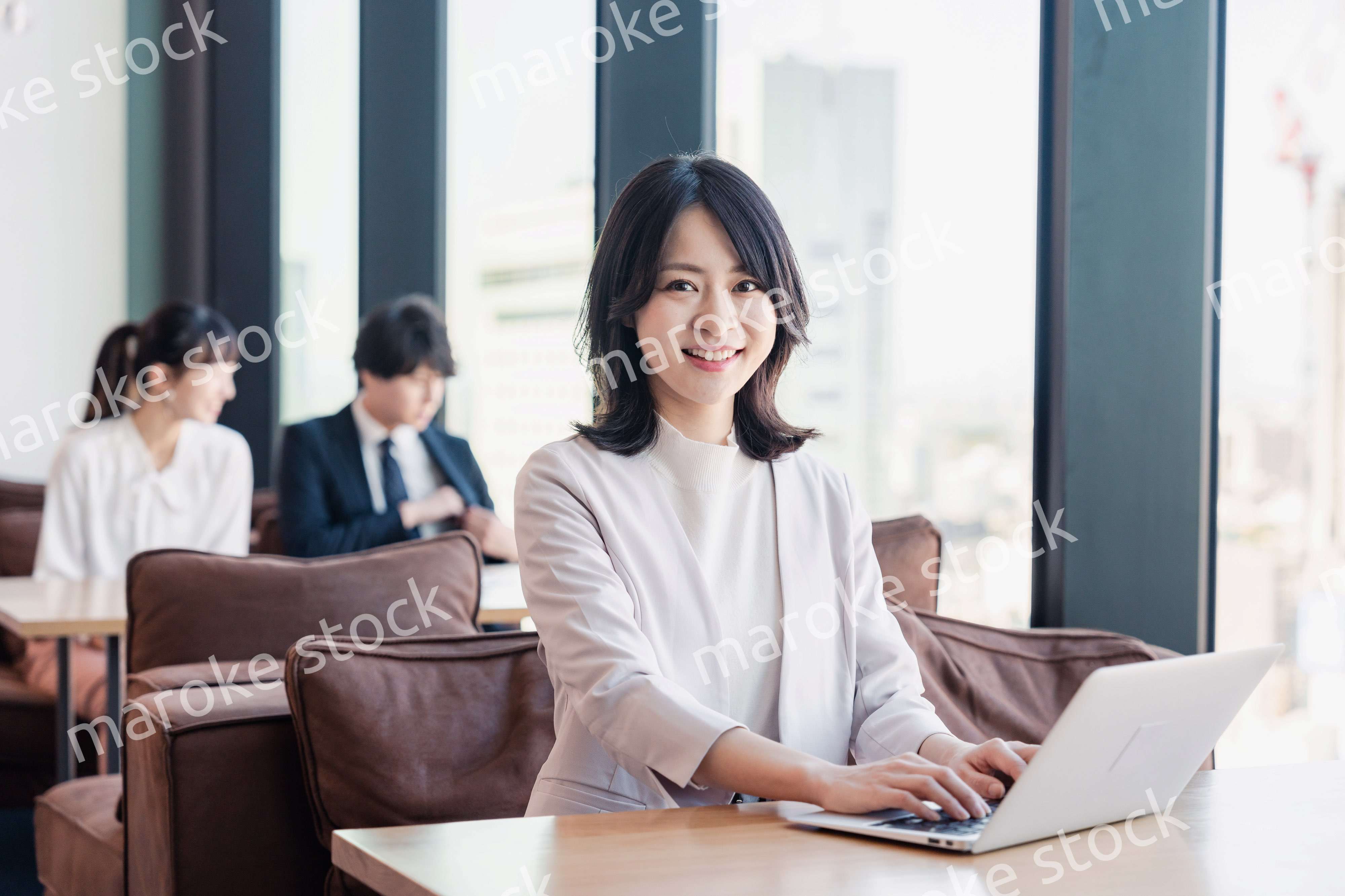 シェアオフィスでノートパソコンを使うビジネスウーマン