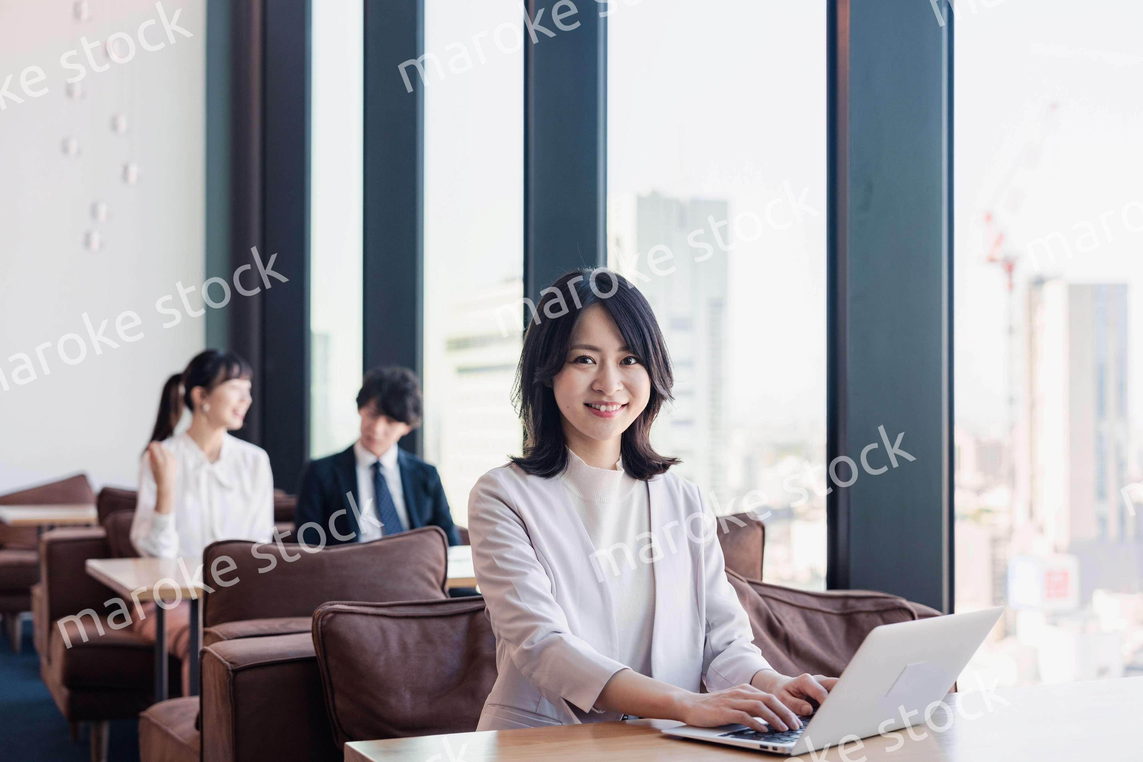 シェアオフィスでノートパソコンを使うビジネスウーマン