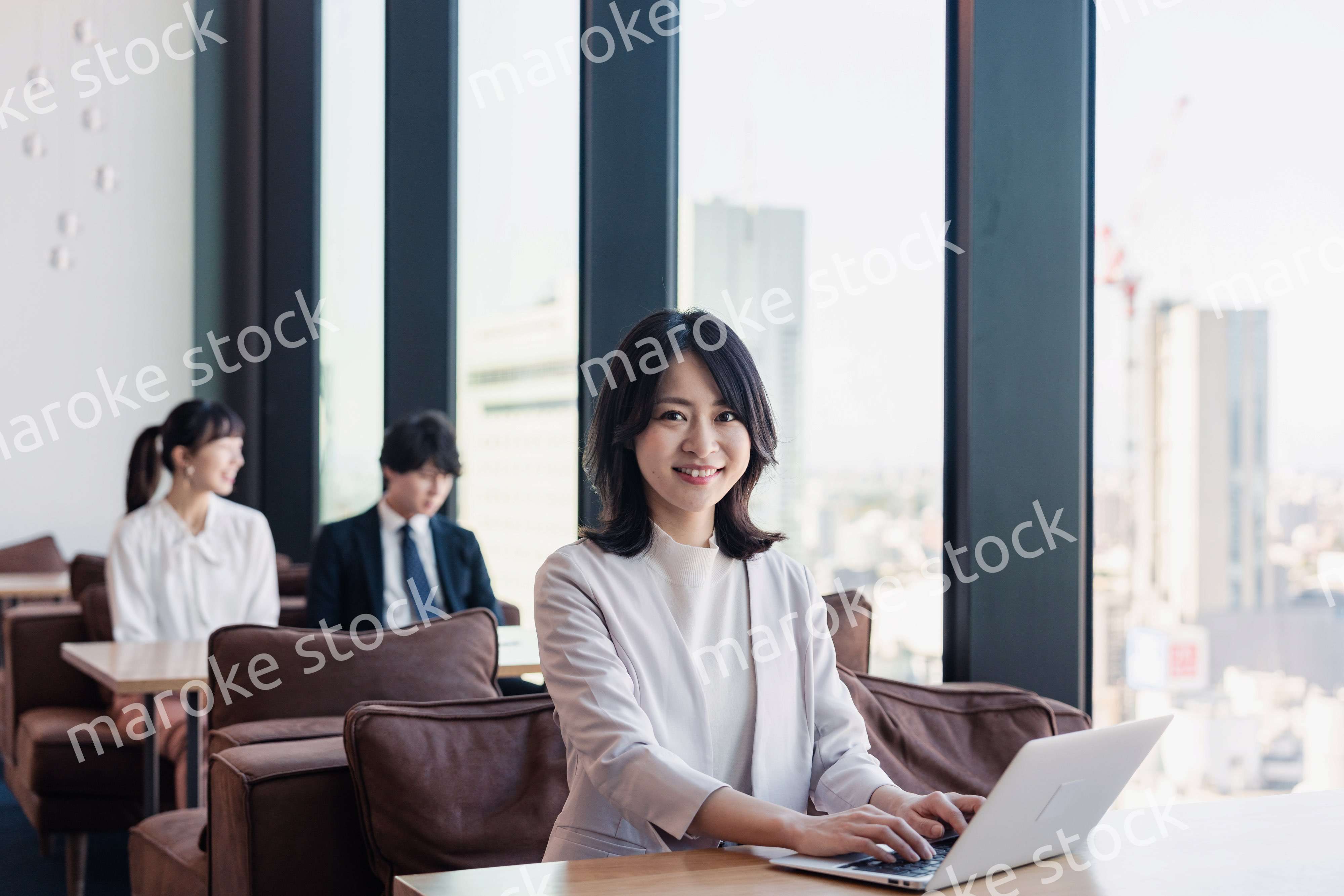 シェアオフィスでノートパソコンを使うビジネスウーマン