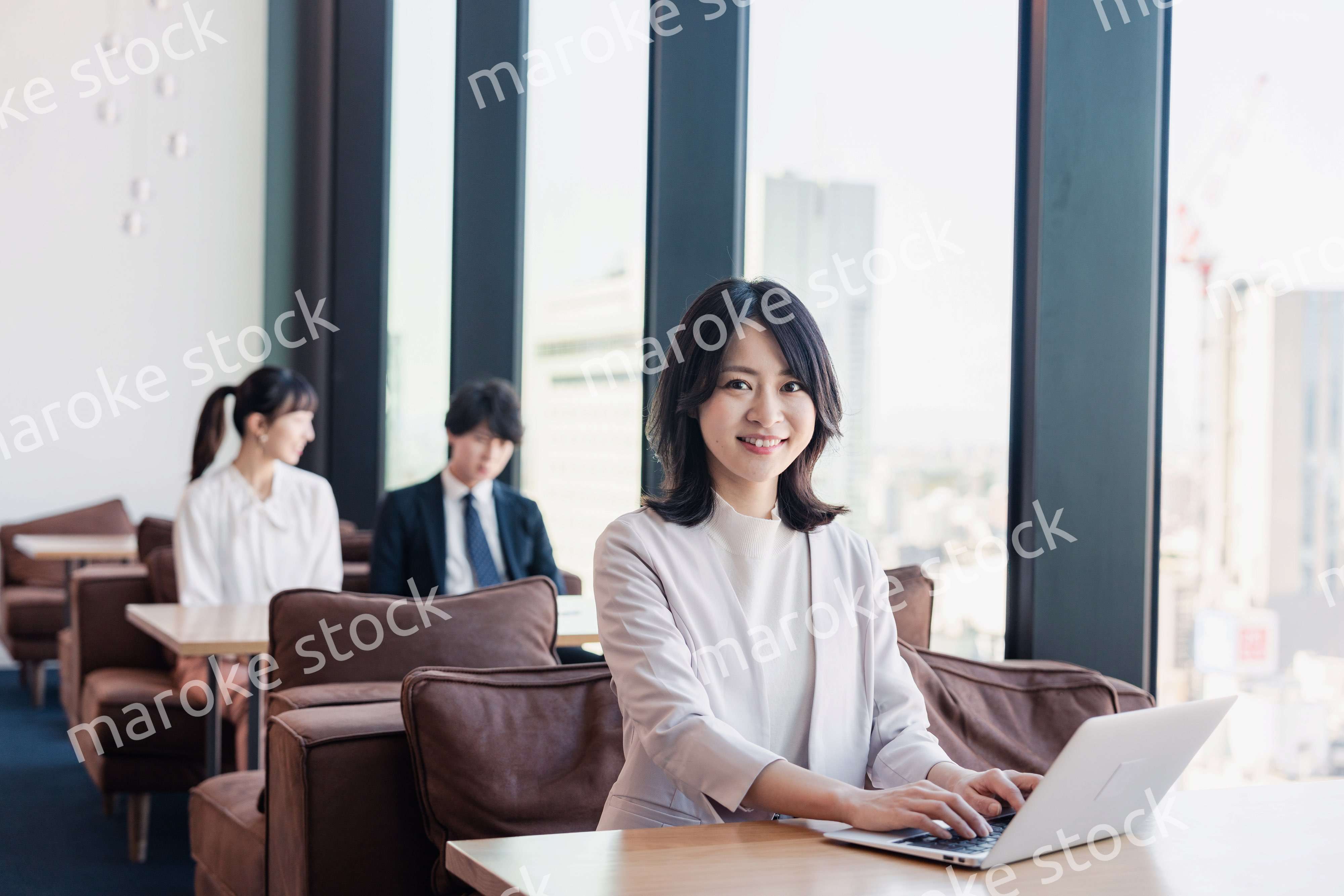 シェアオフィスでノートパソコンを使うビジネスウーマン