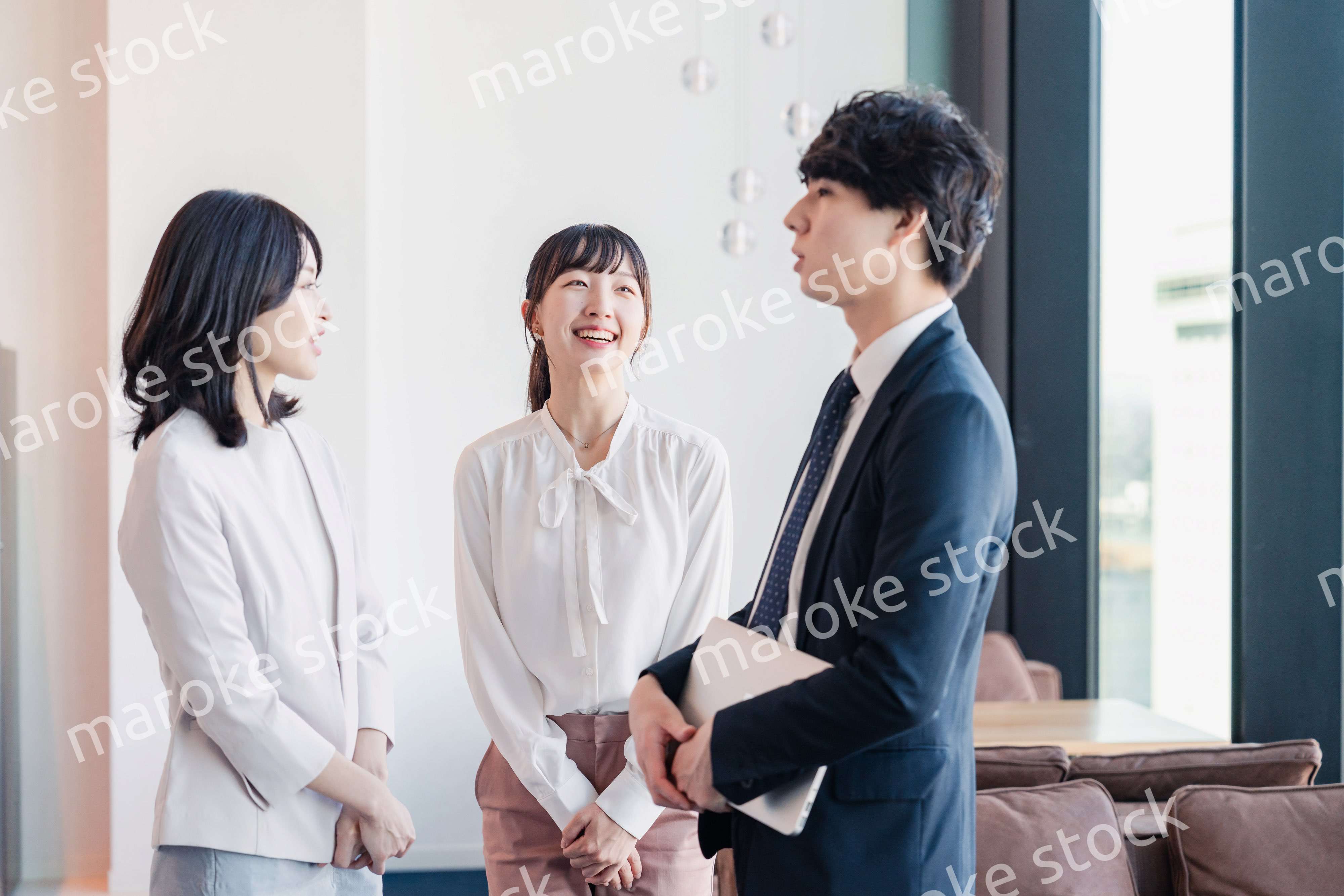 オフィスで仲良く話す若いビジネスパーソン