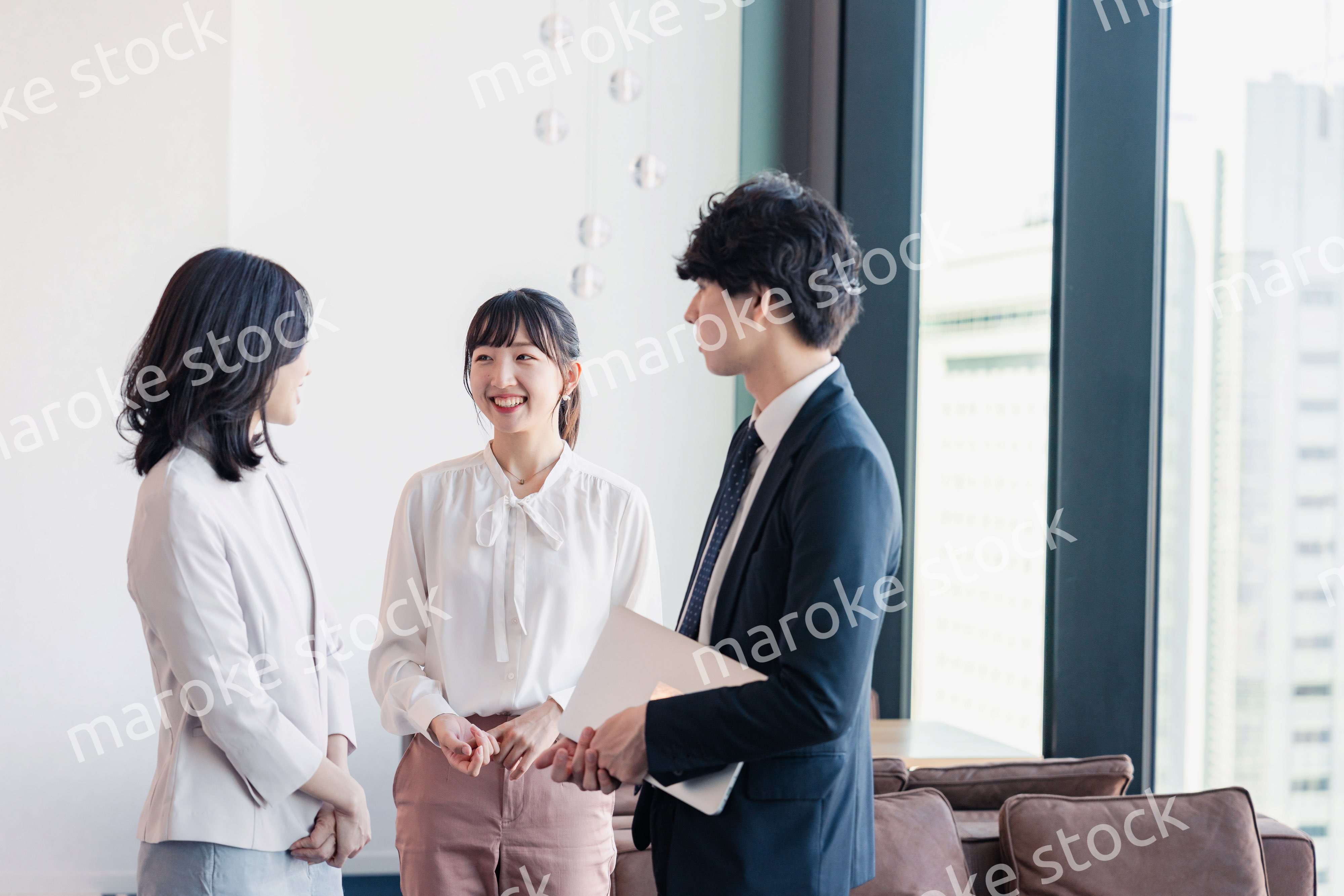 オフィスで仲良く話す若いビジネスパーソン