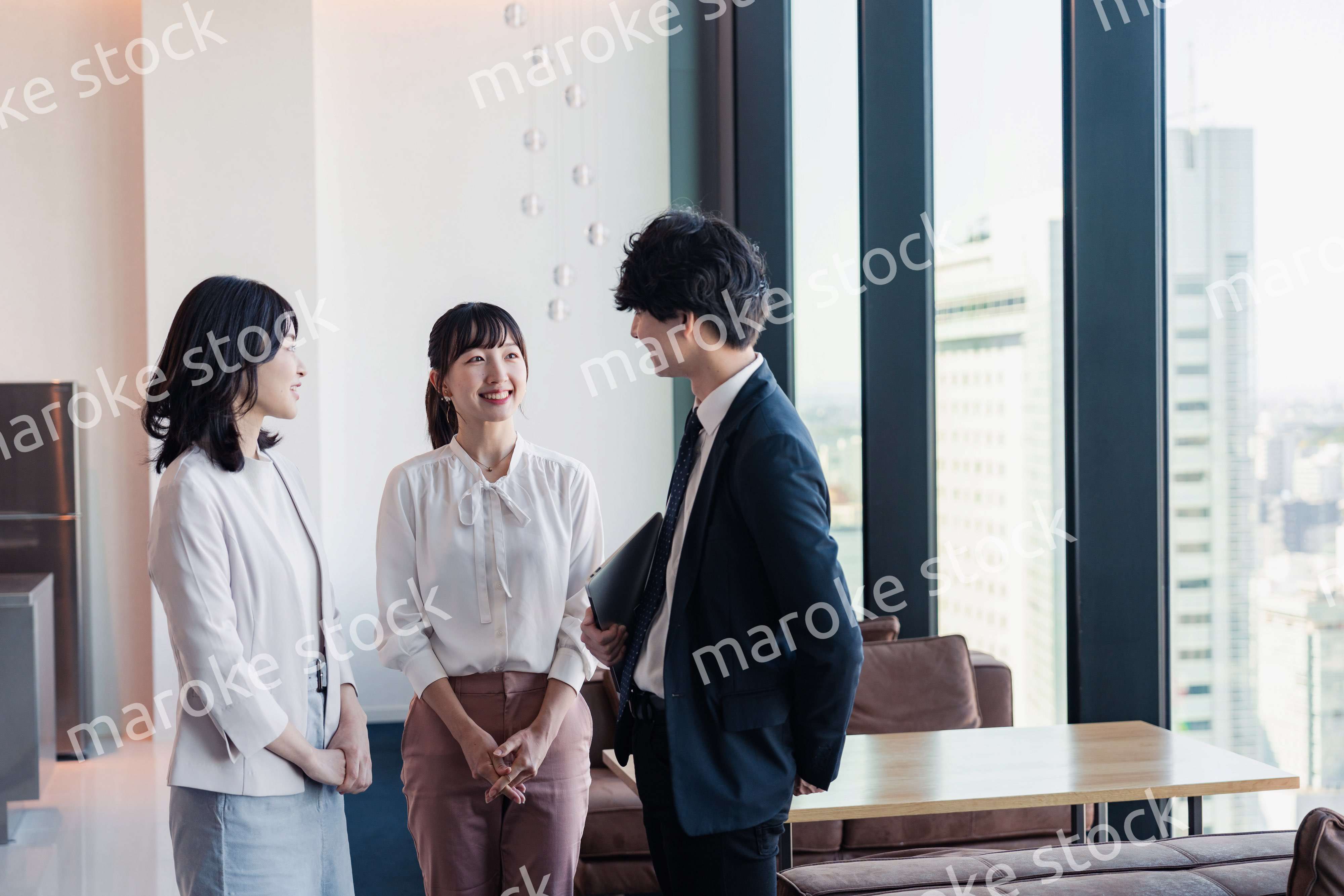 オフィスで仲良く話す若いビジネスパーソン