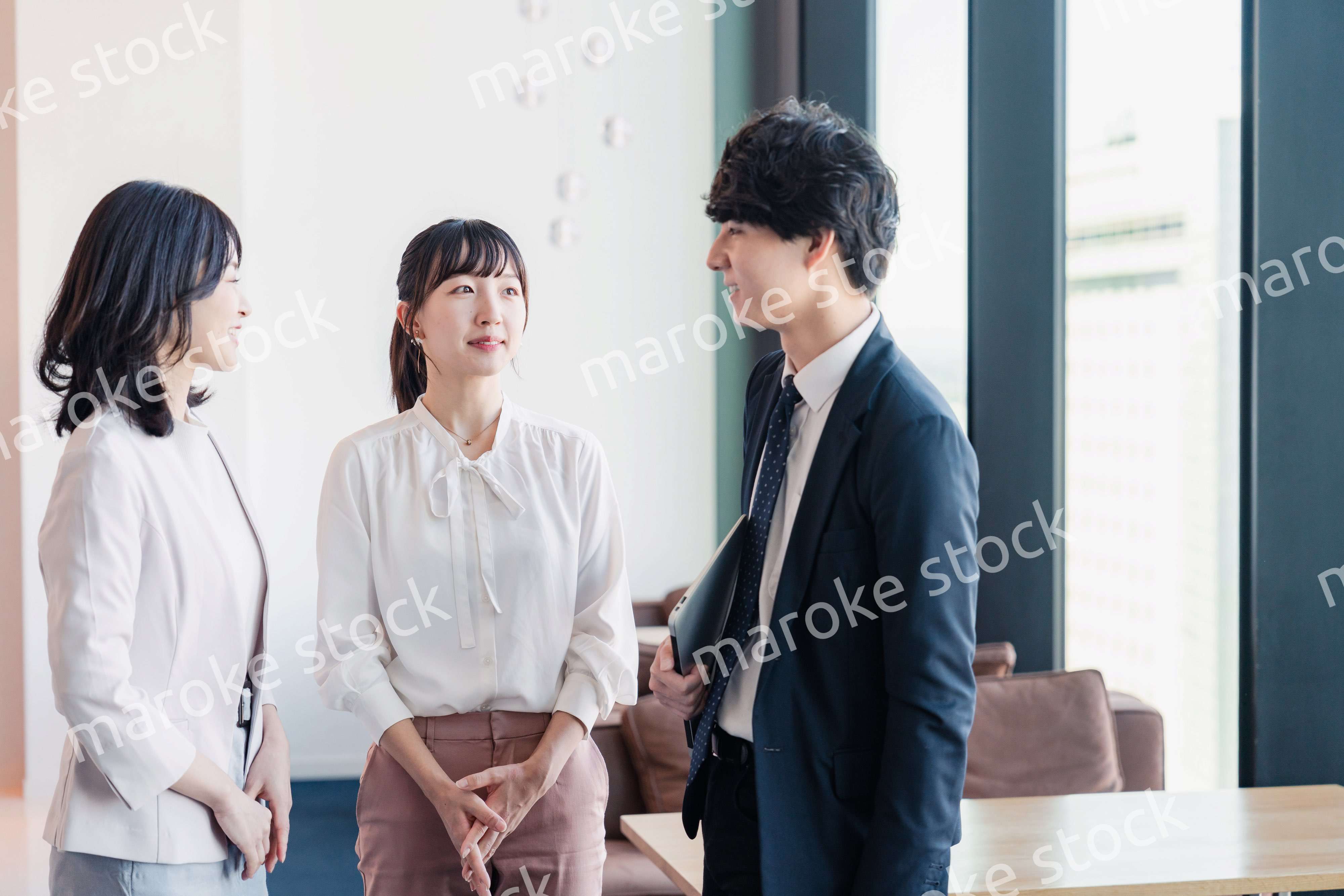 オフィスで仲良く話す若いビジネスパーソン