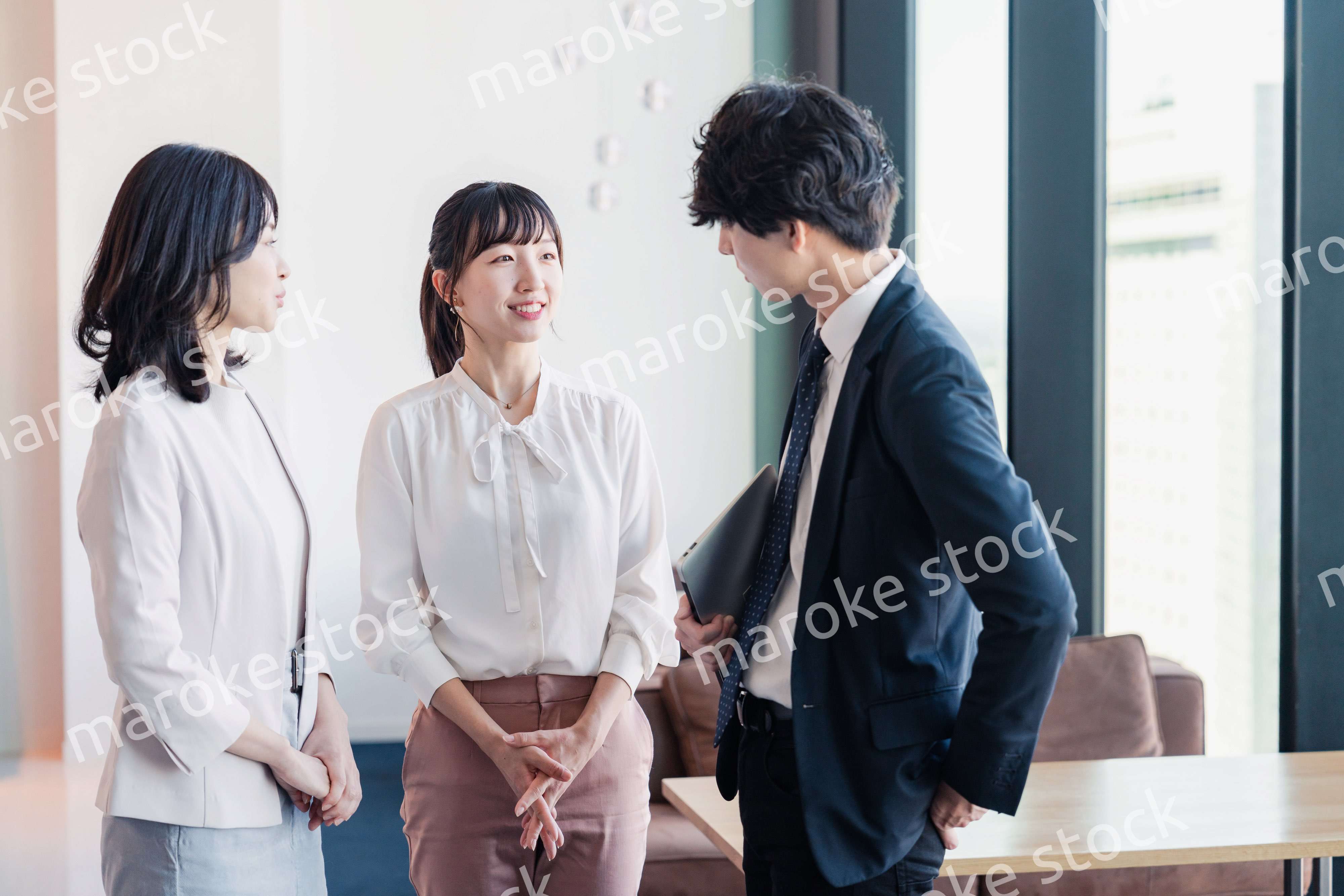 オフィスで仲良く話す若いビジネスパーソン