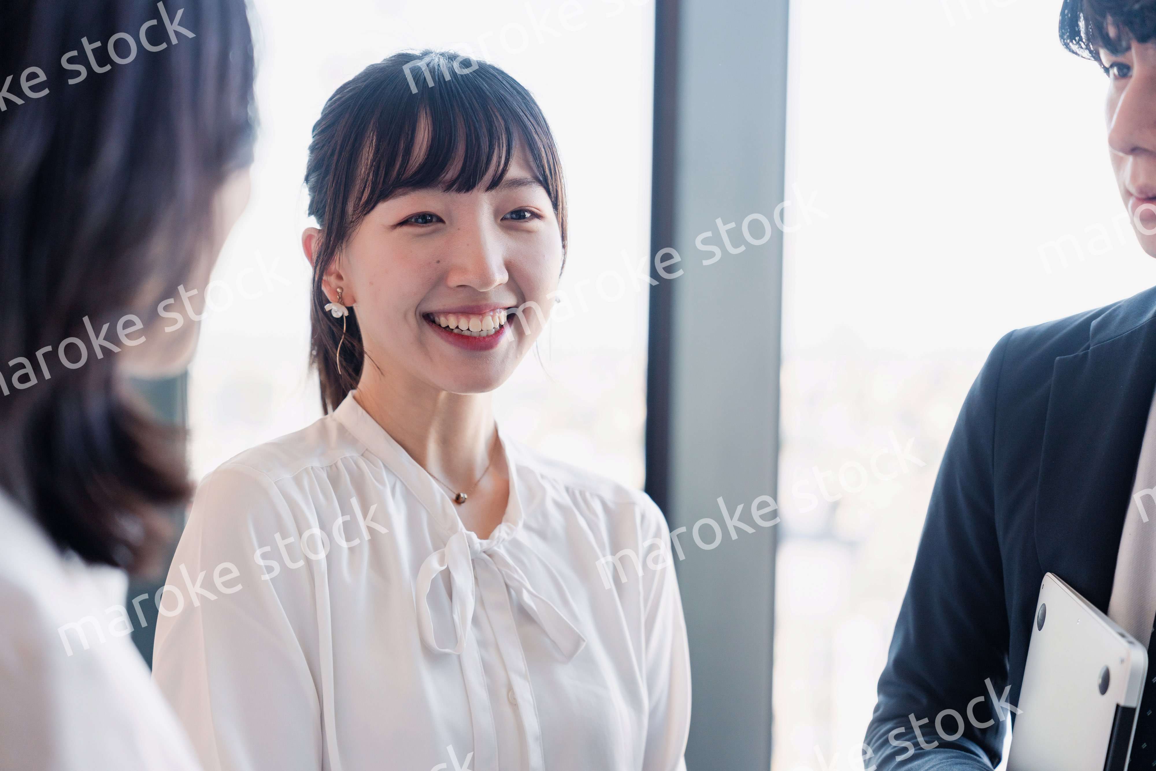 オフィスで仲良く話す若いビジネスパーソン