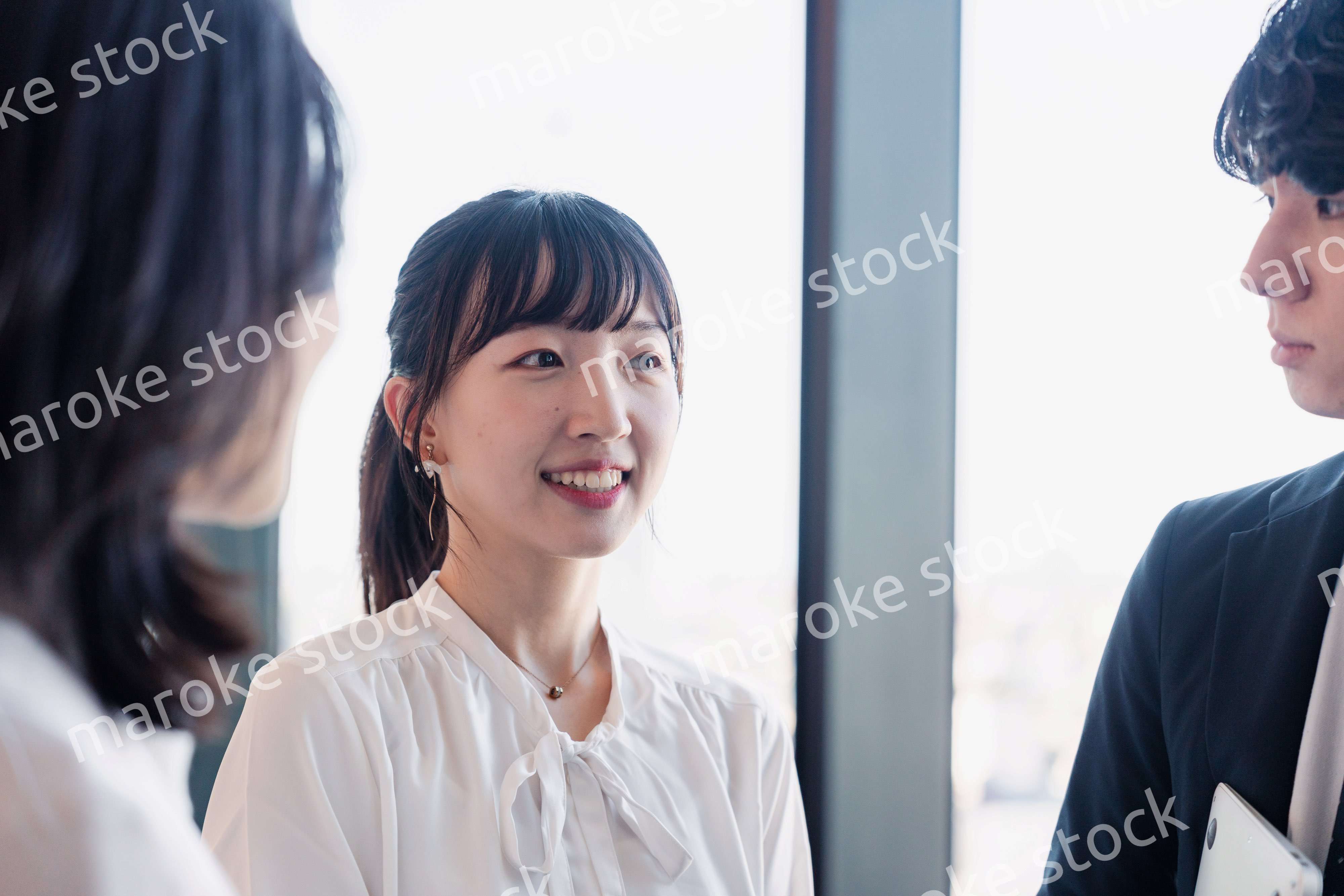 オフィスで仲良く話す若いビジネスパーソン