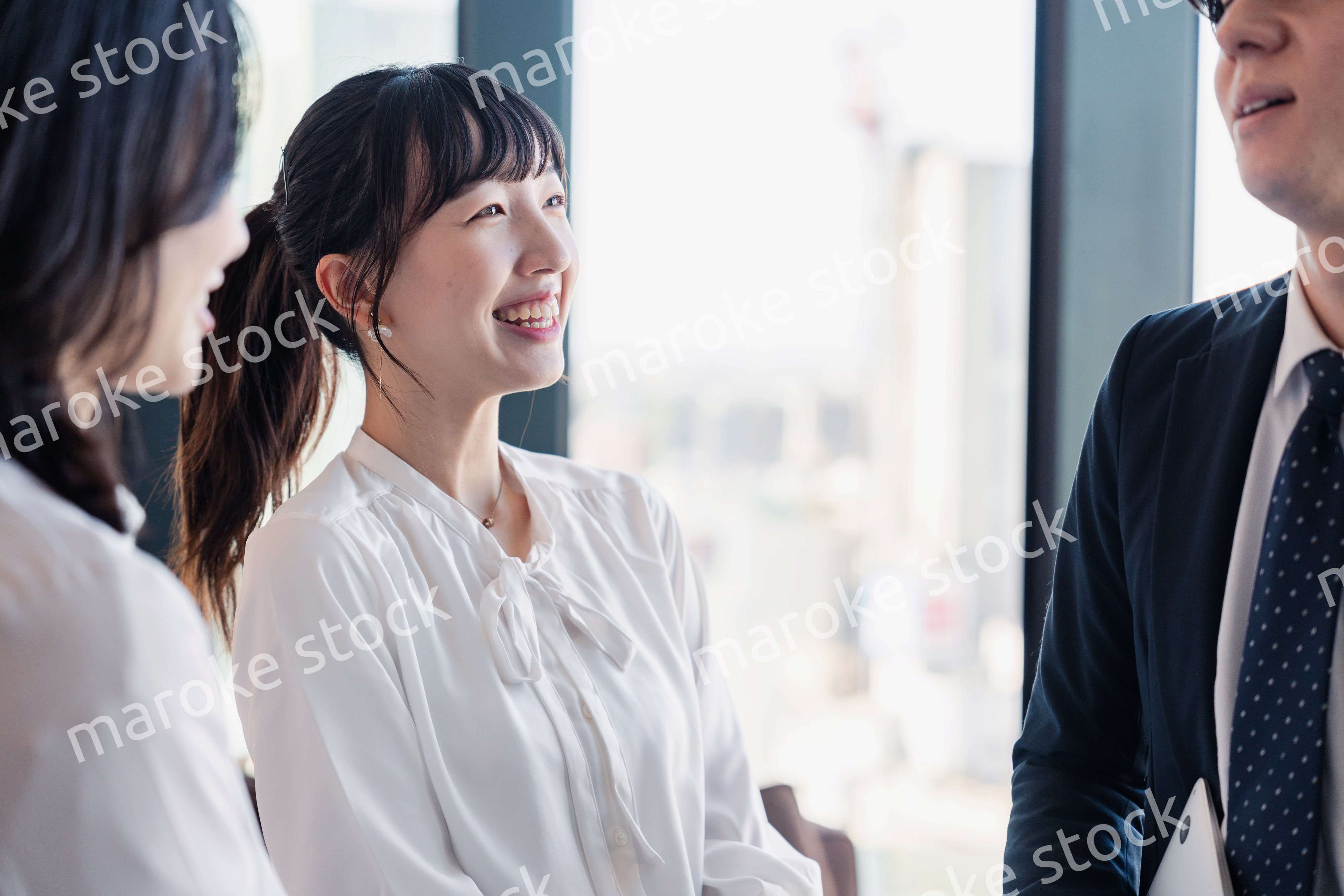 オフィスで仲良く話す若いビジネスパーソン