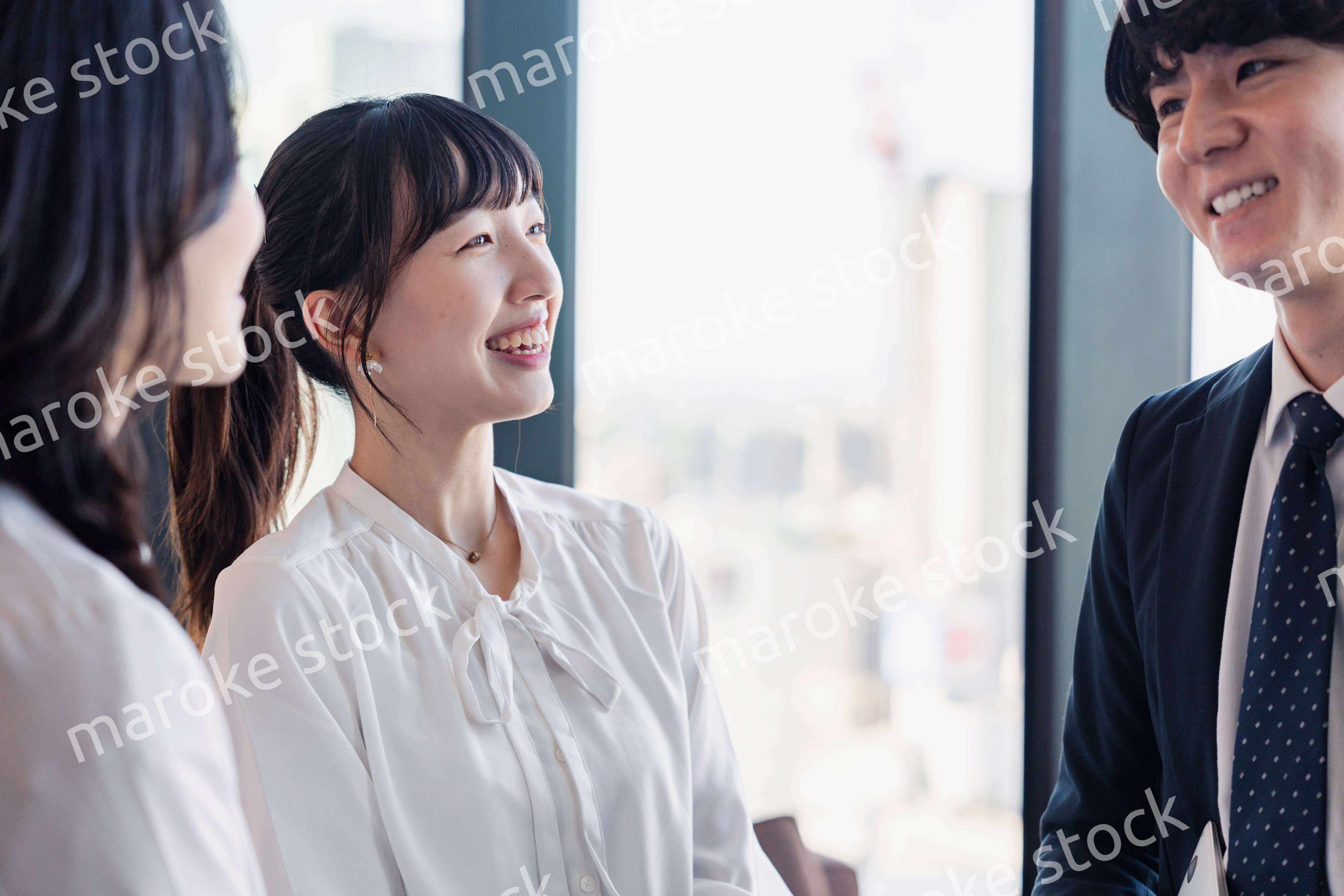 オフィスで仲良く話す若いビジネスパーソン