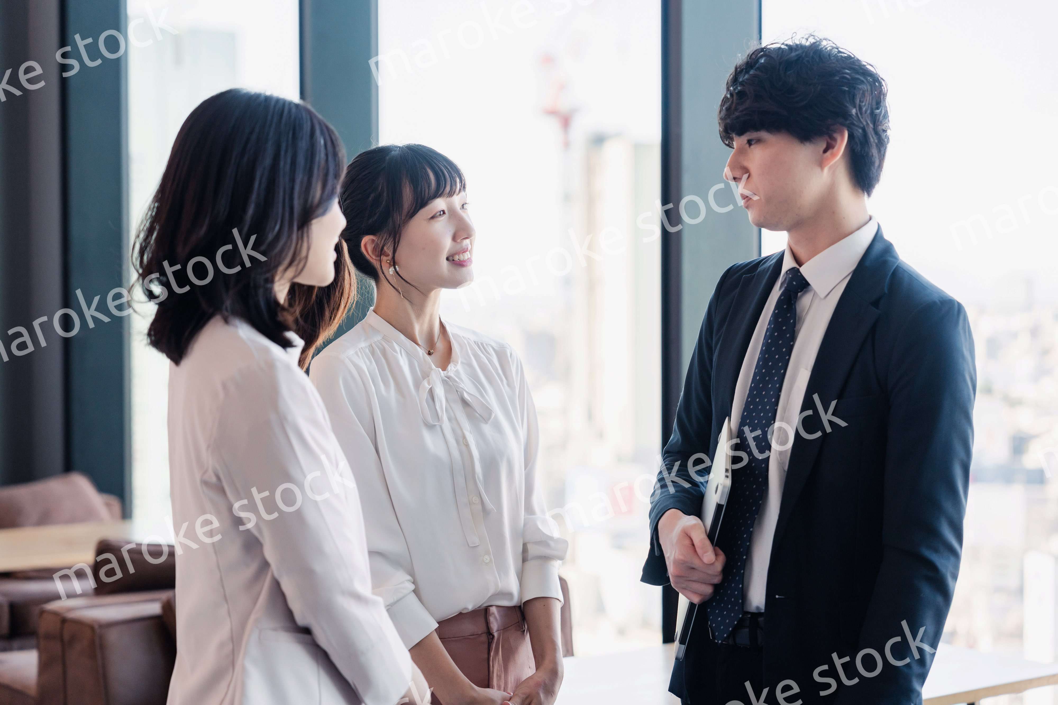 オフィスで仲良く話す若いビジネスパーソン