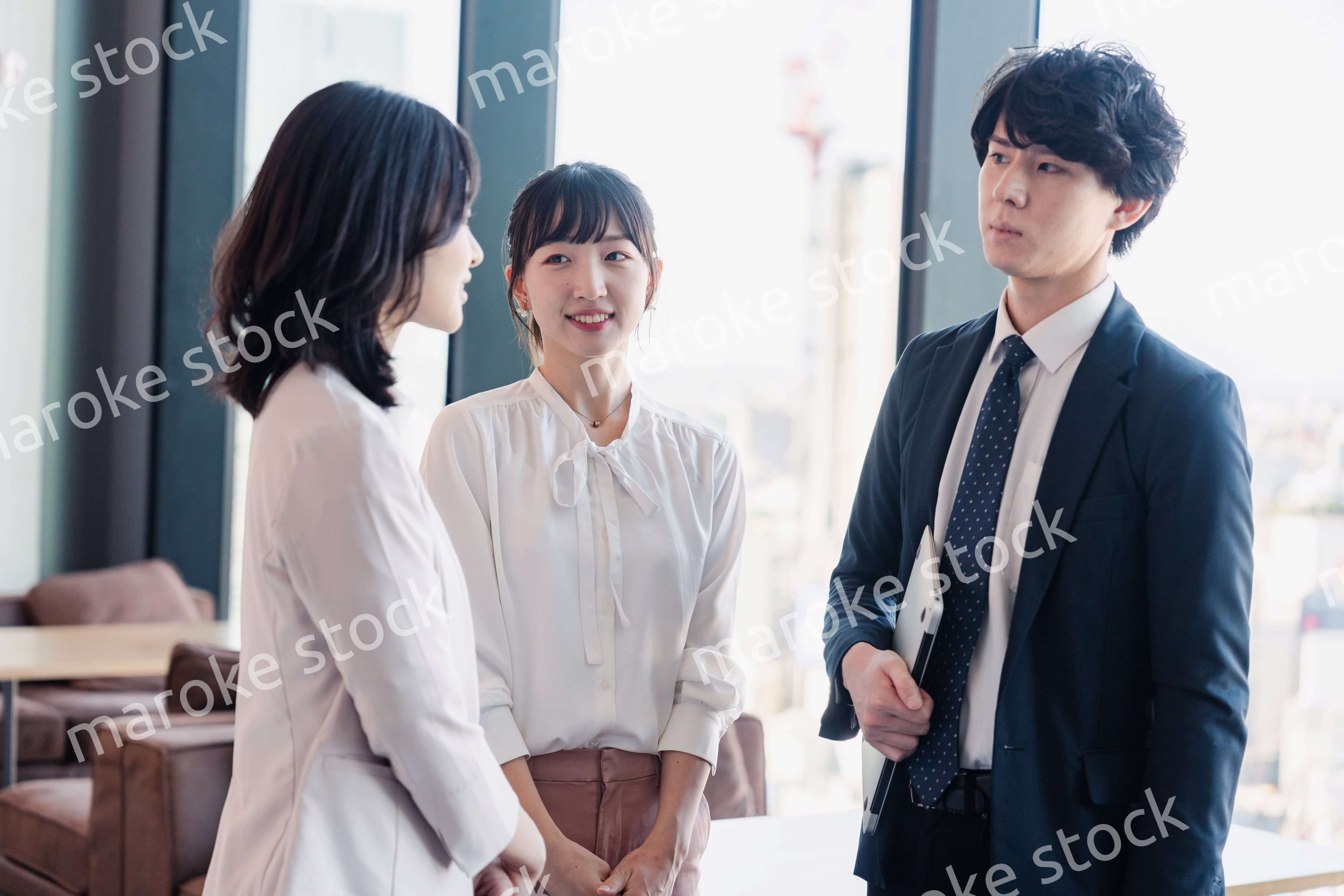 オフィスで仲良く話す若いビジネスパーソン