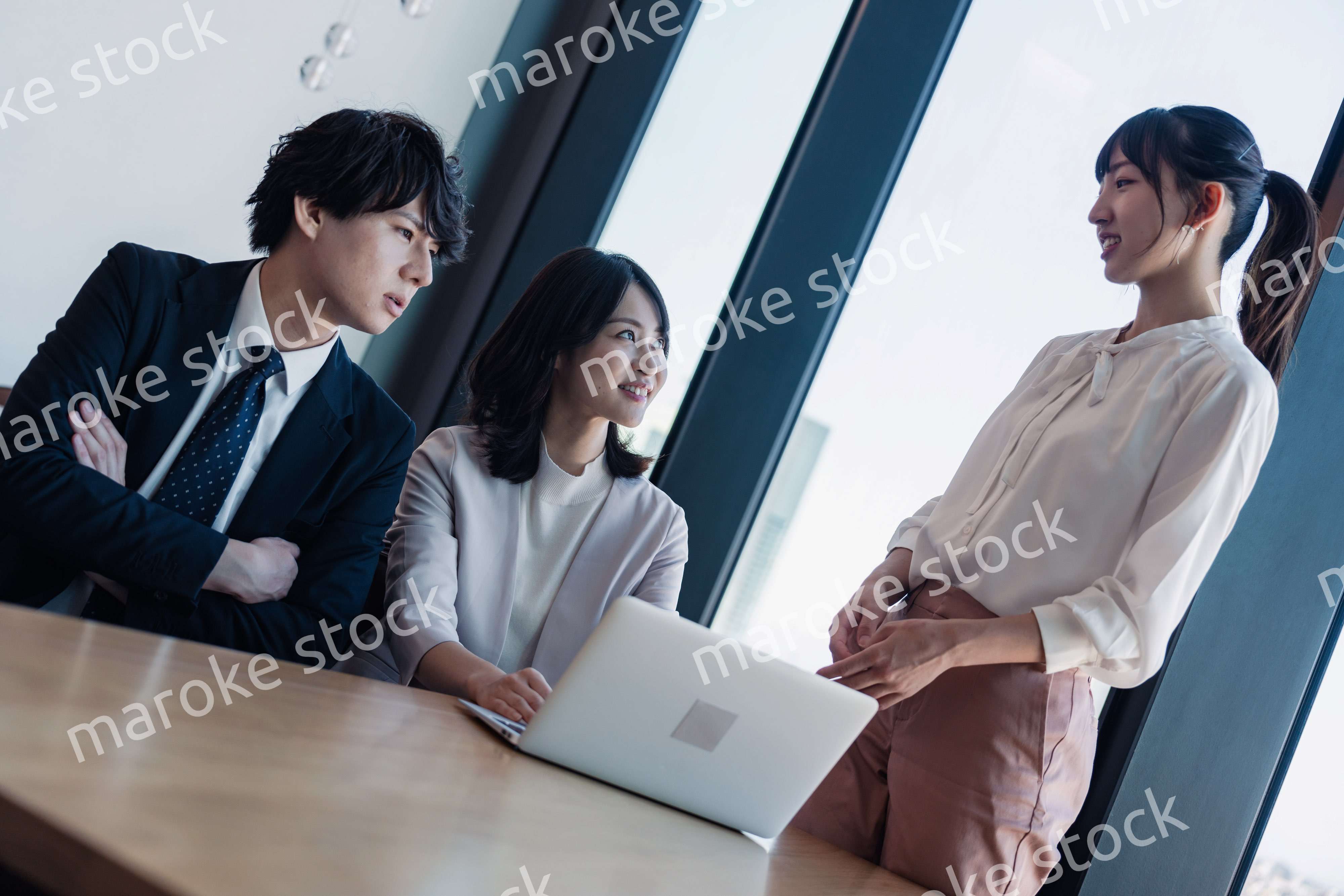 オフィスで仲良く話す若いビジネスパーソン