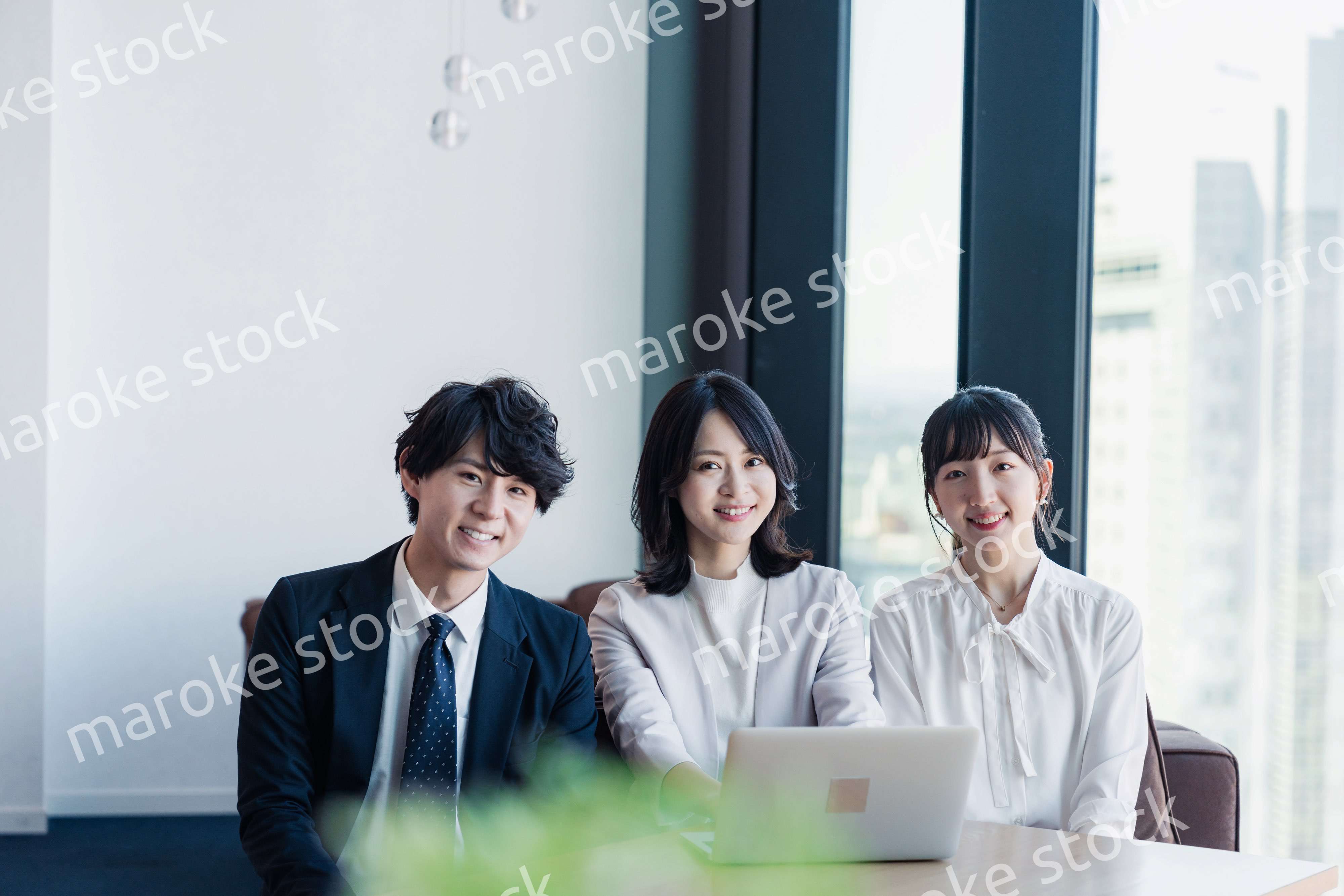 オフィスで仲良く話す若いビジネスパーソン