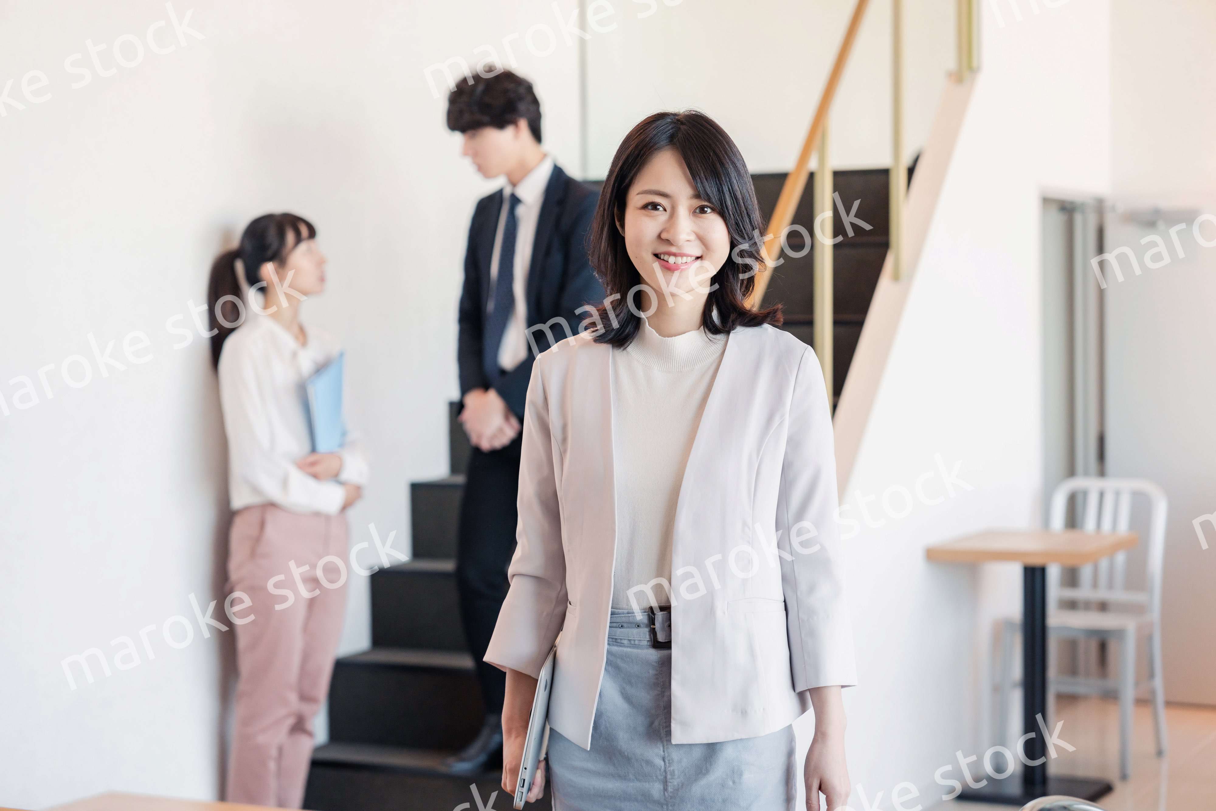 笑顔でオフィスを歩く女性経営者