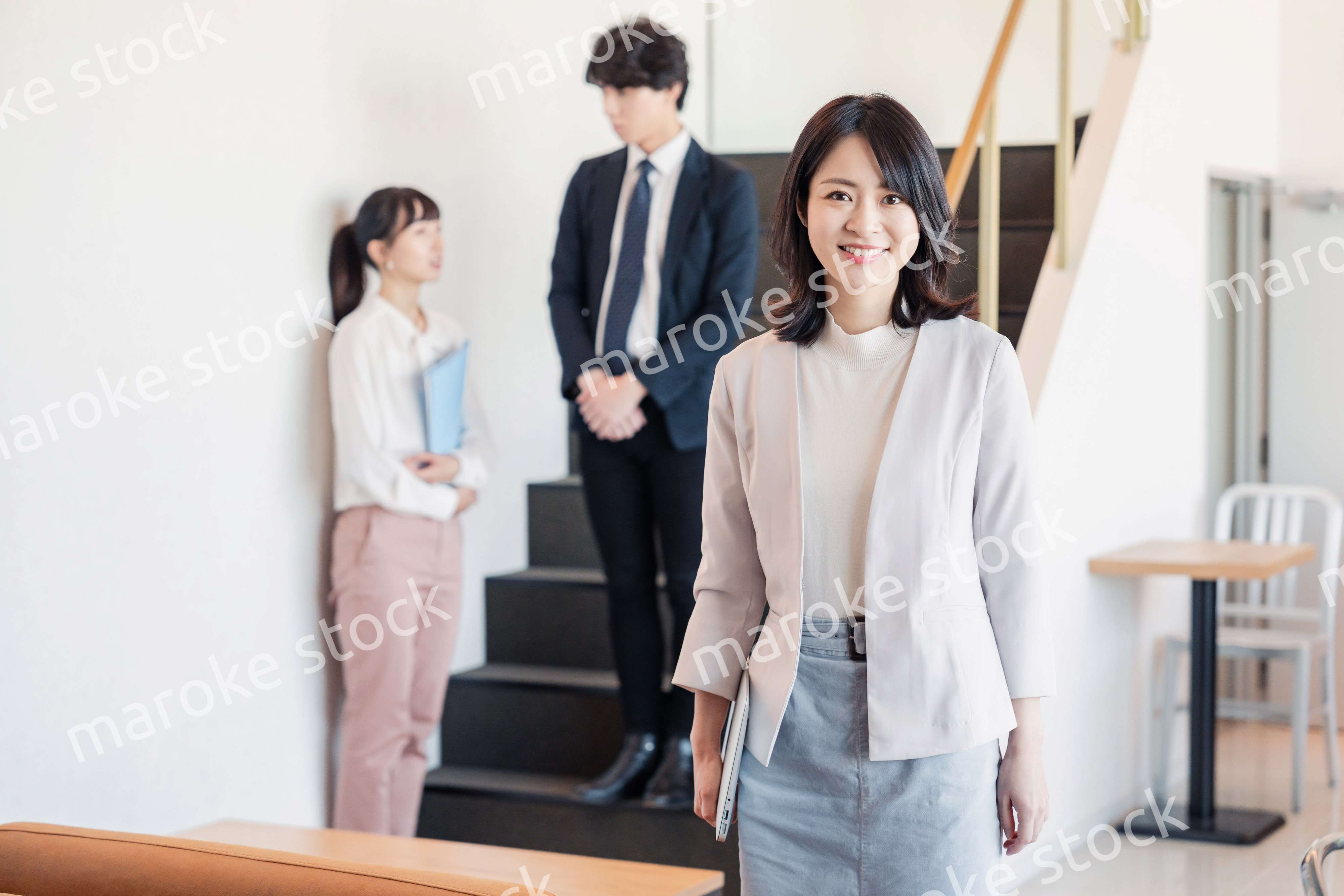 笑顔でオフィスを歩く女性経営者