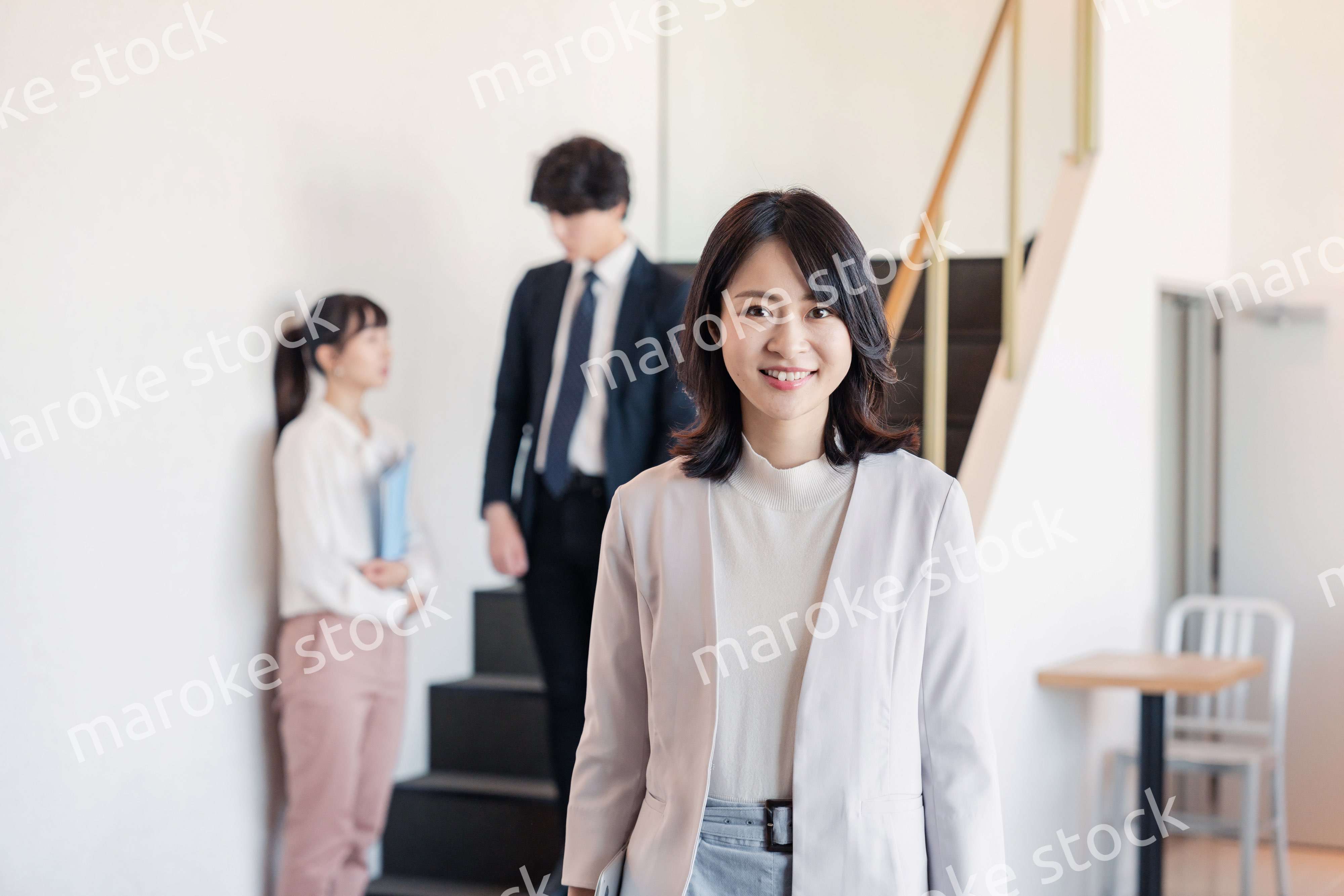 笑顔でオフィスを歩く女性経営者