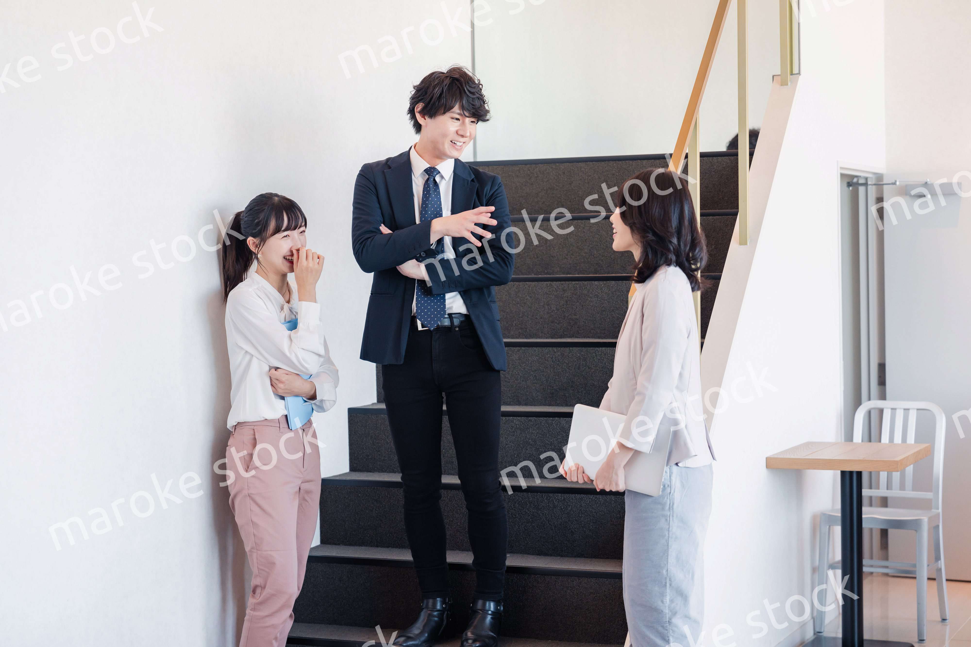 オフィスで仲良く話す若いビジネスパーソン