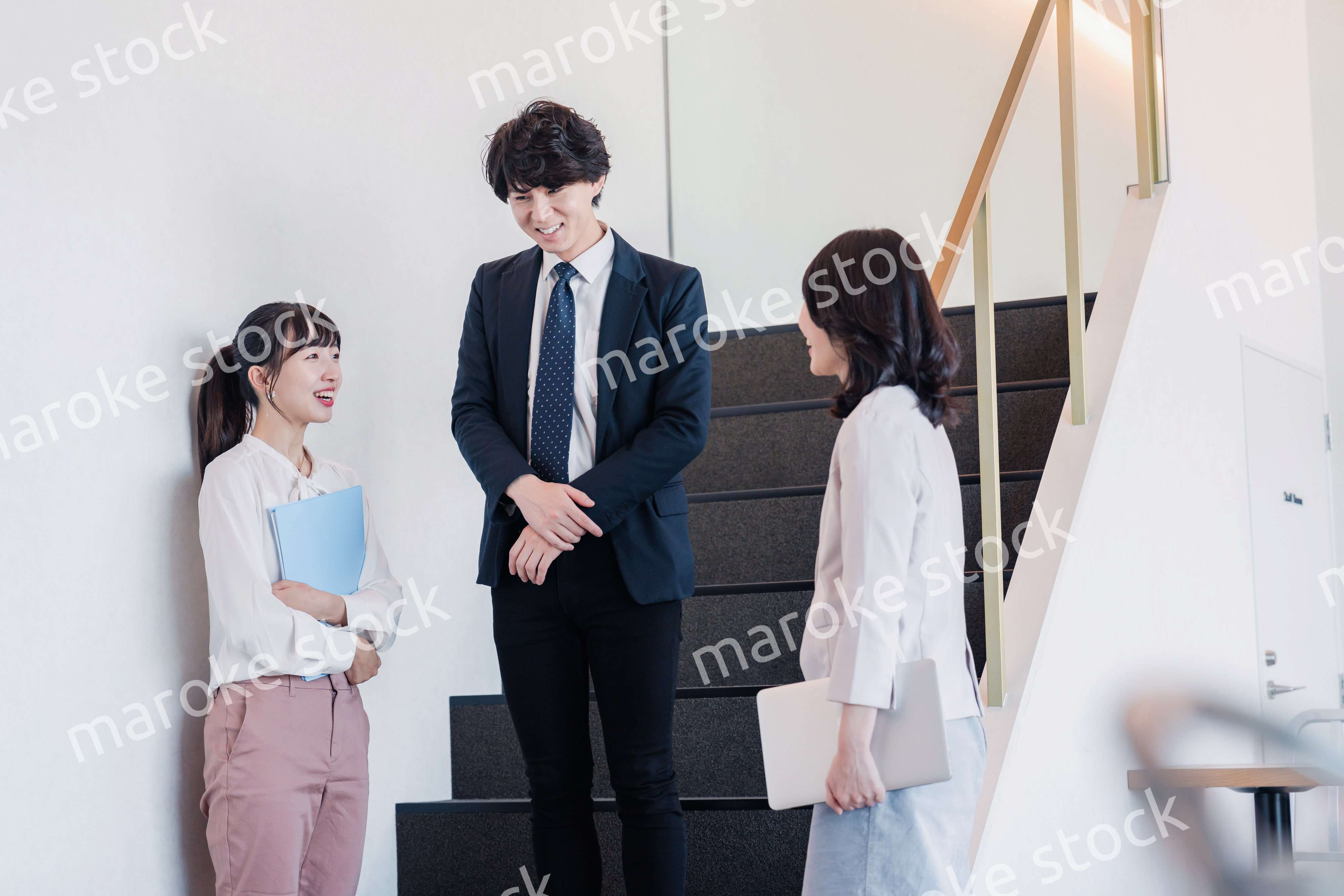 オフィスで仲良く話す若いビジネスパーソン