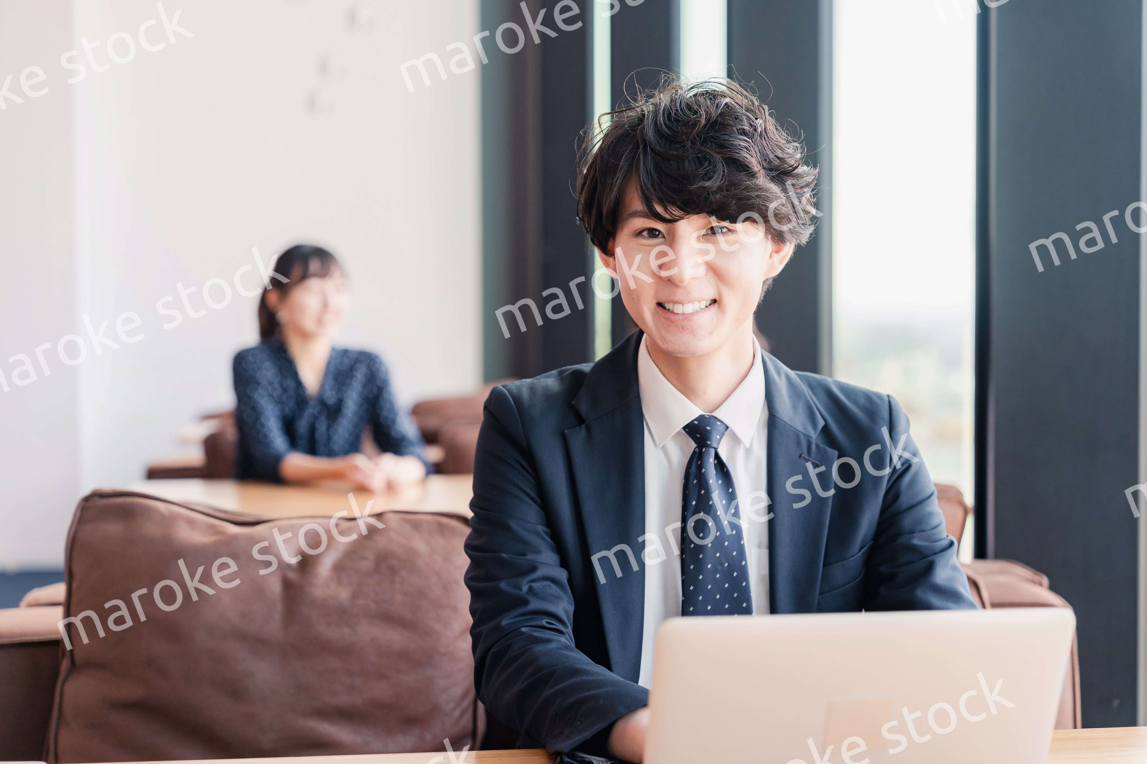 オフィスで笑顔で働くビジネスマン