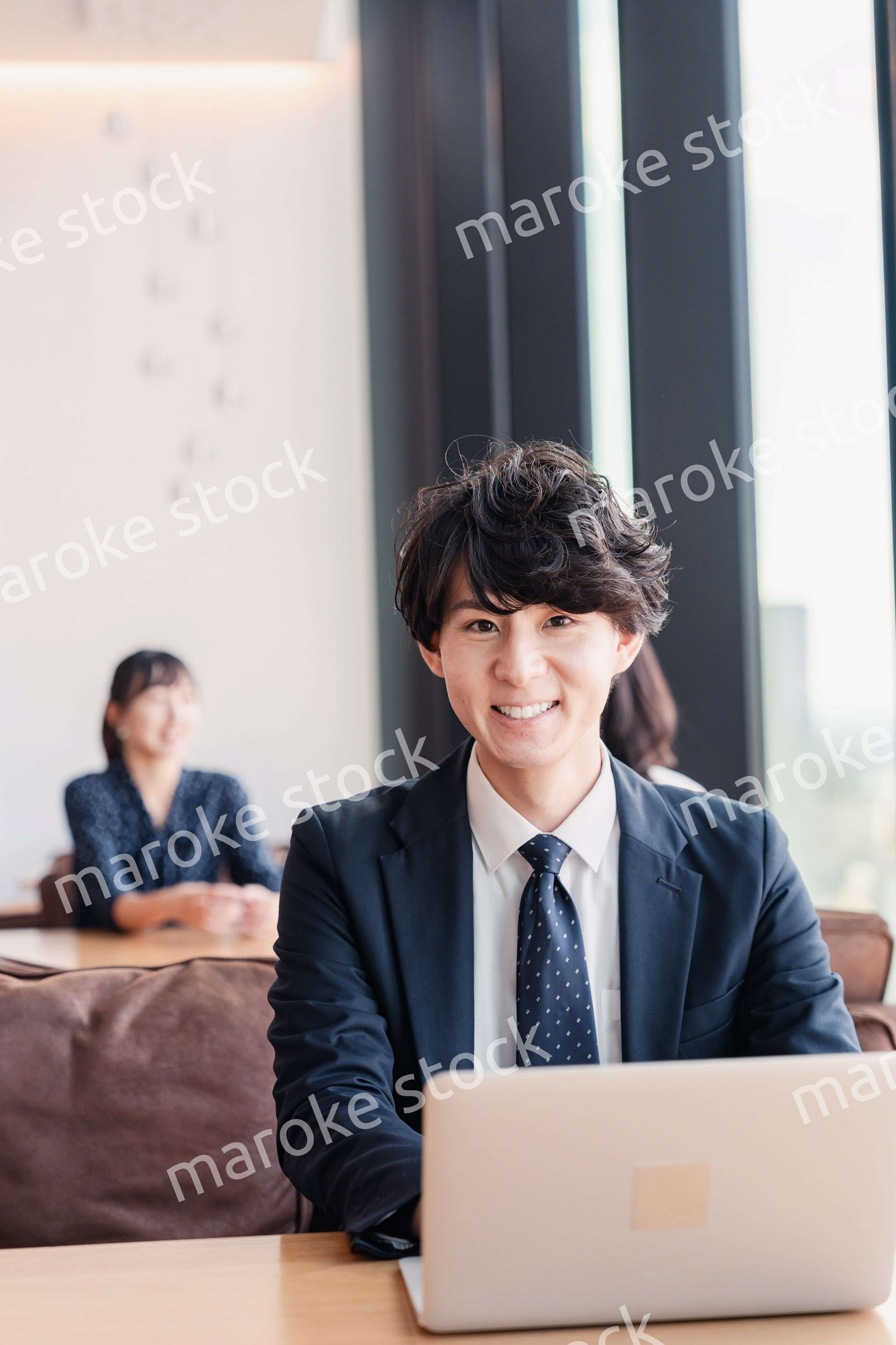 オフィスで笑顔で働くビジネスマン