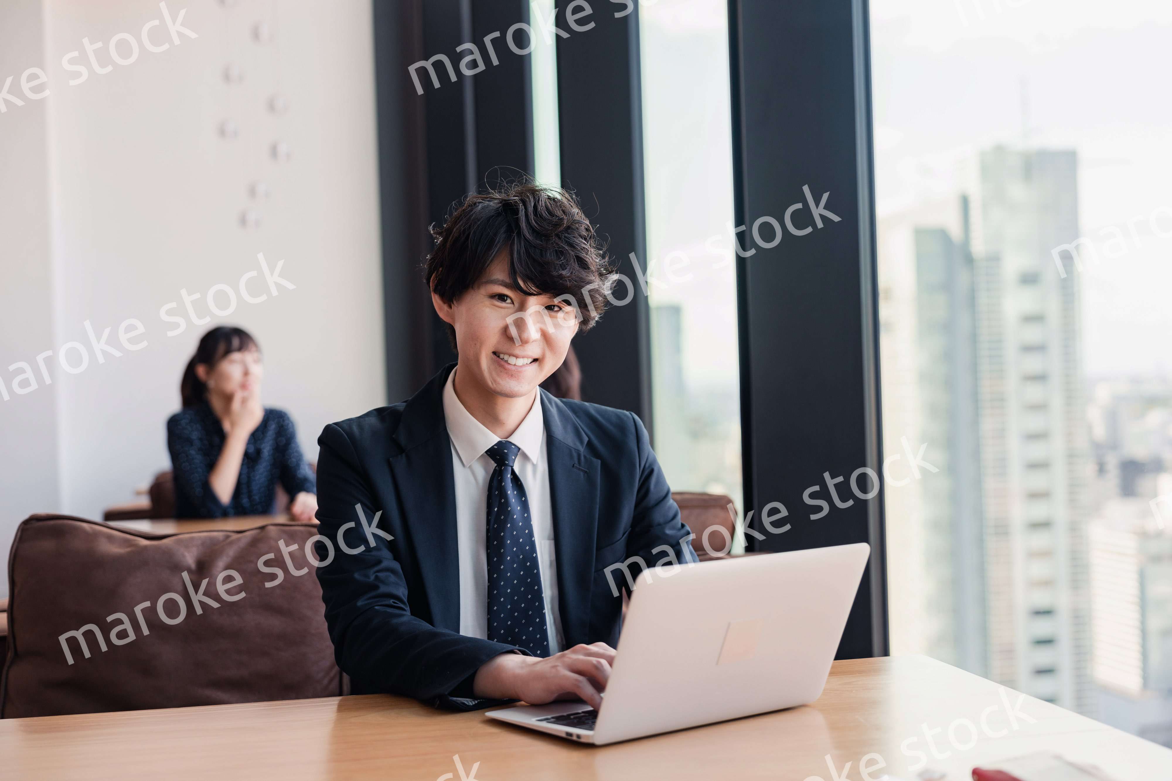 オフィスで笑顔で働くビジネスマン