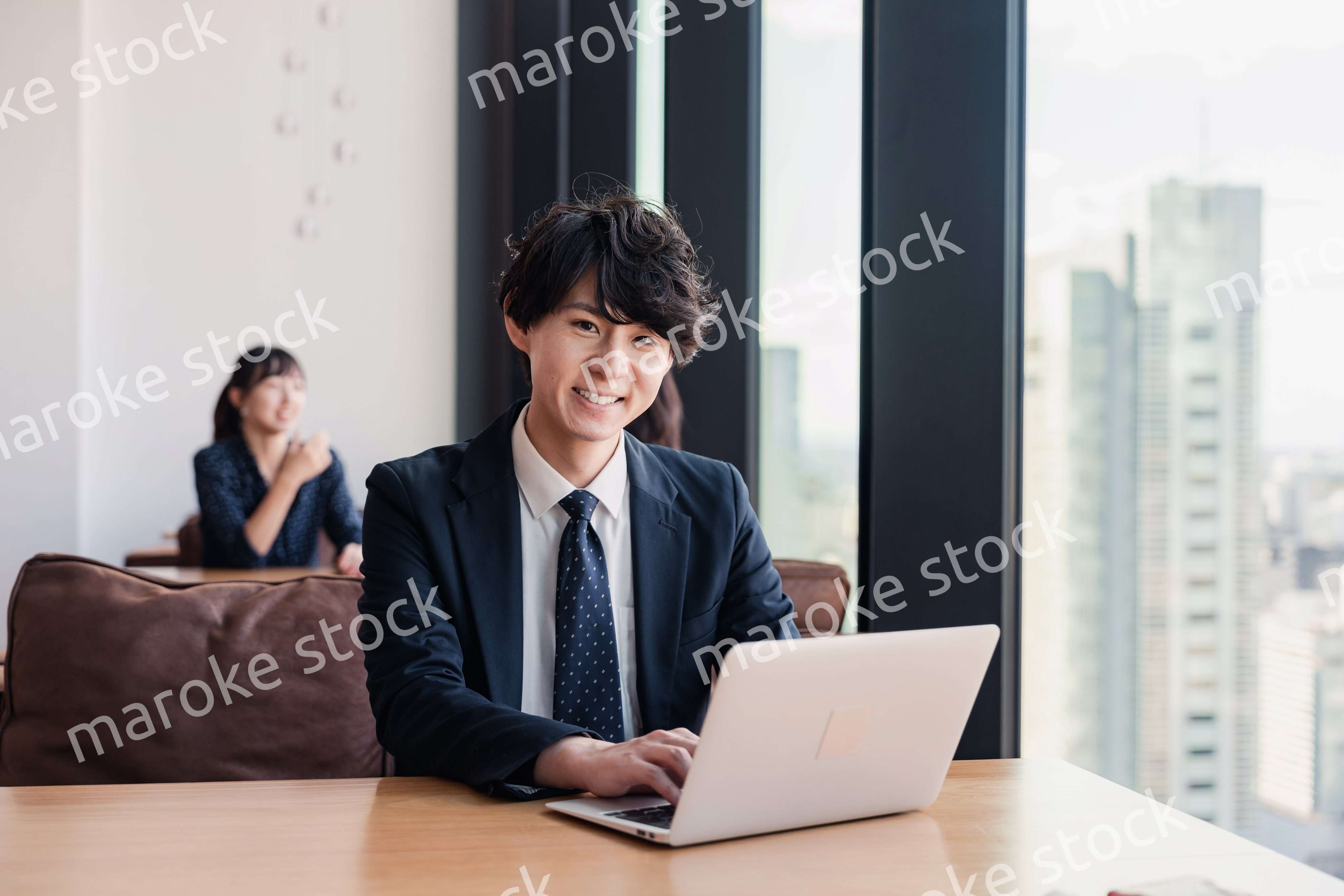 オフィスで笑顔で働くビジネスマン