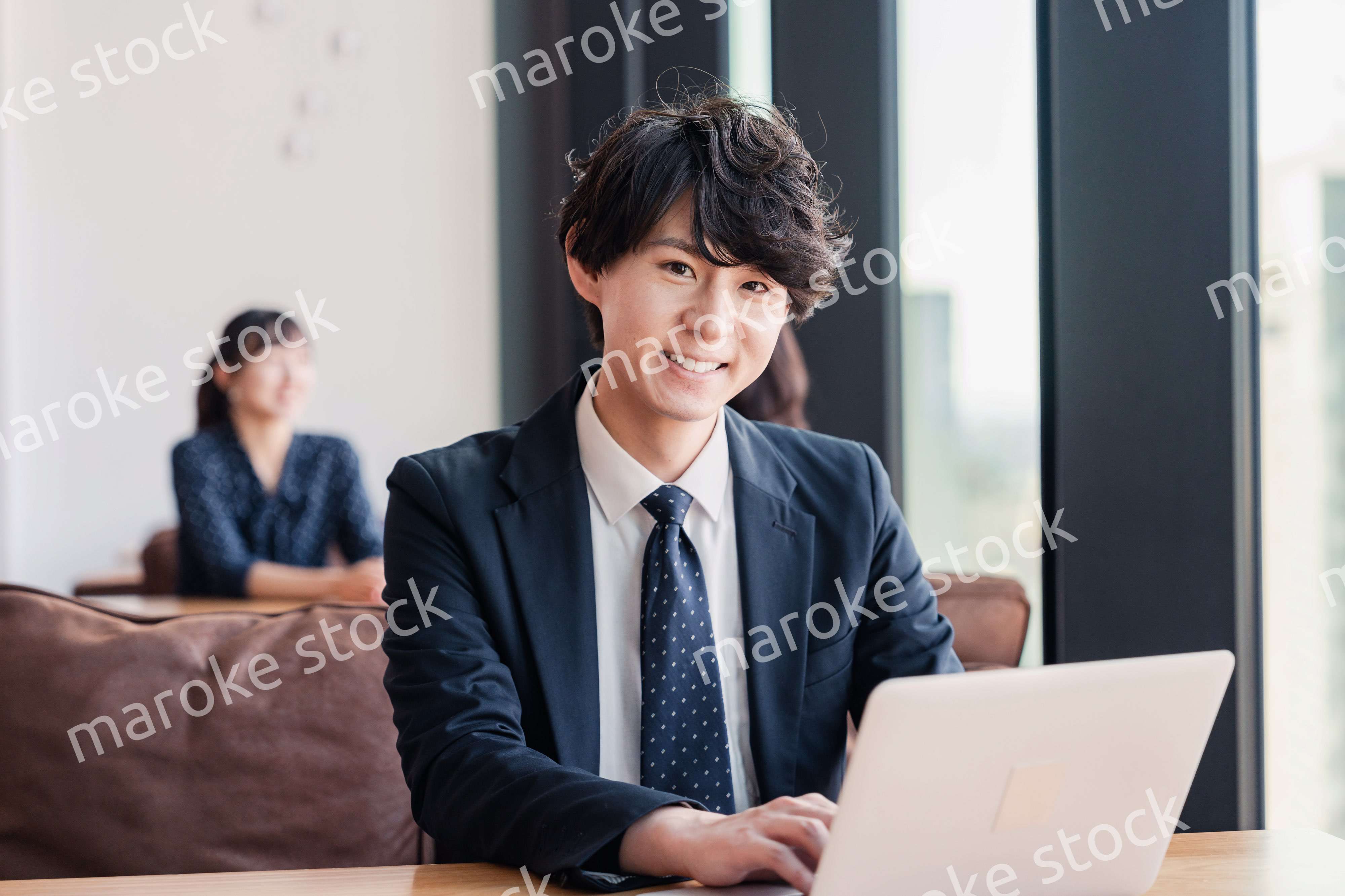 オフィスで笑顔で働くビジネスマン