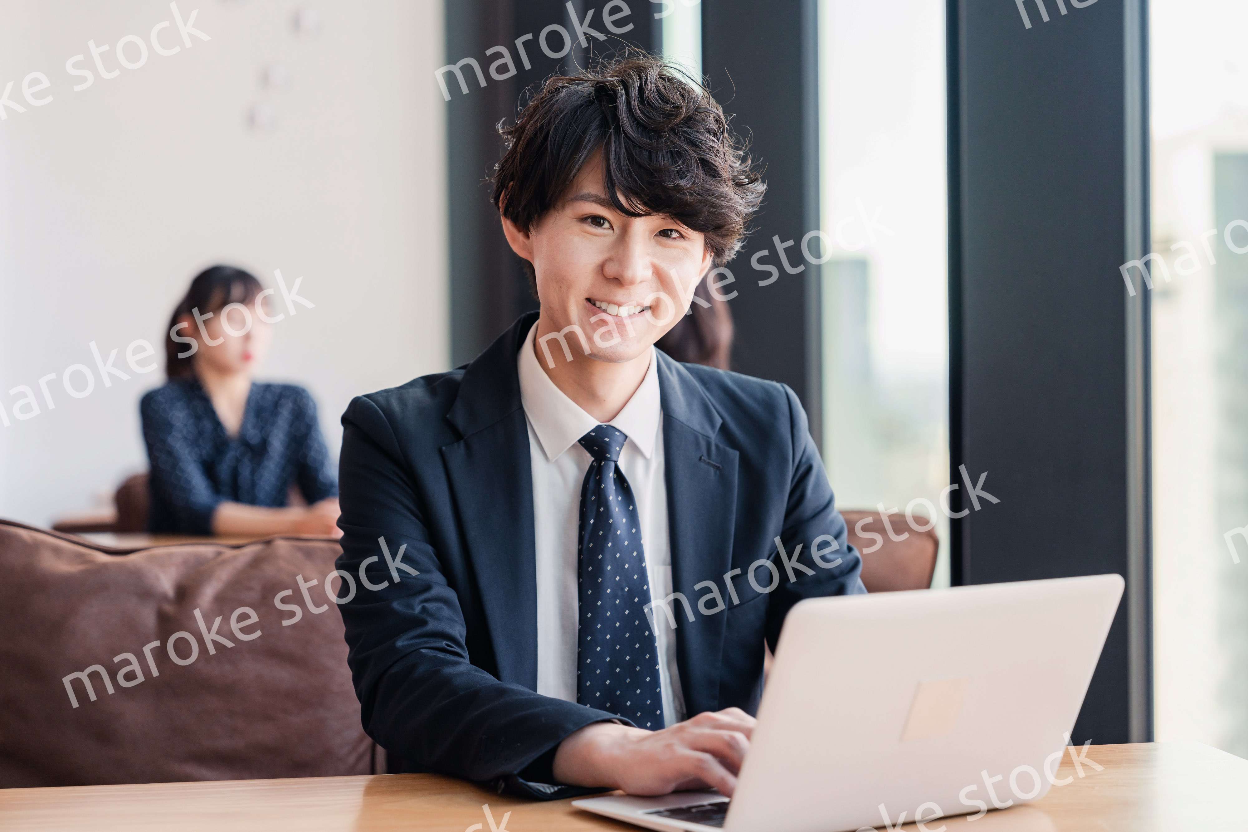 オフィスで笑顔で働くビジネスマン