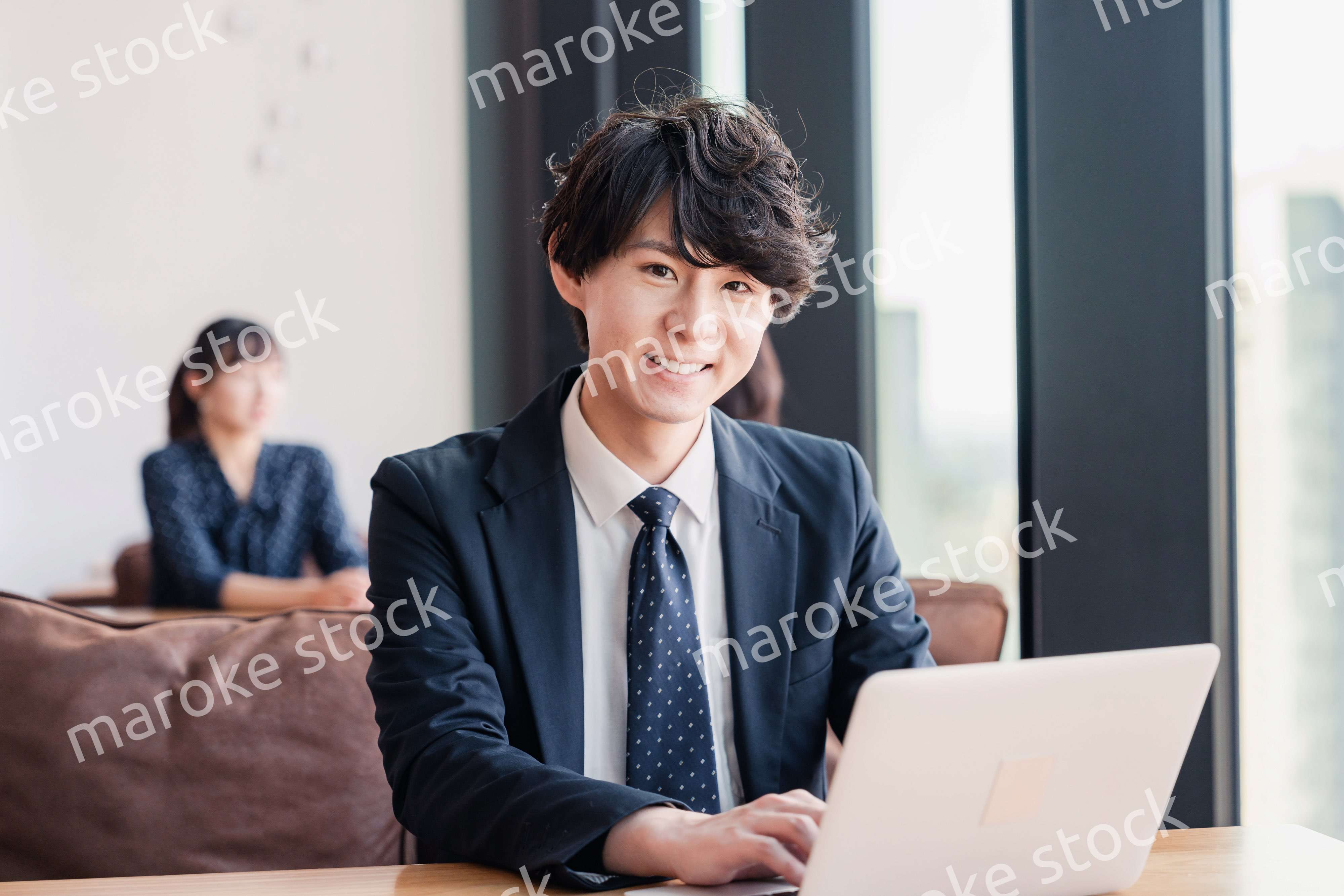 オフィスで笑顔で働くビジネスマン