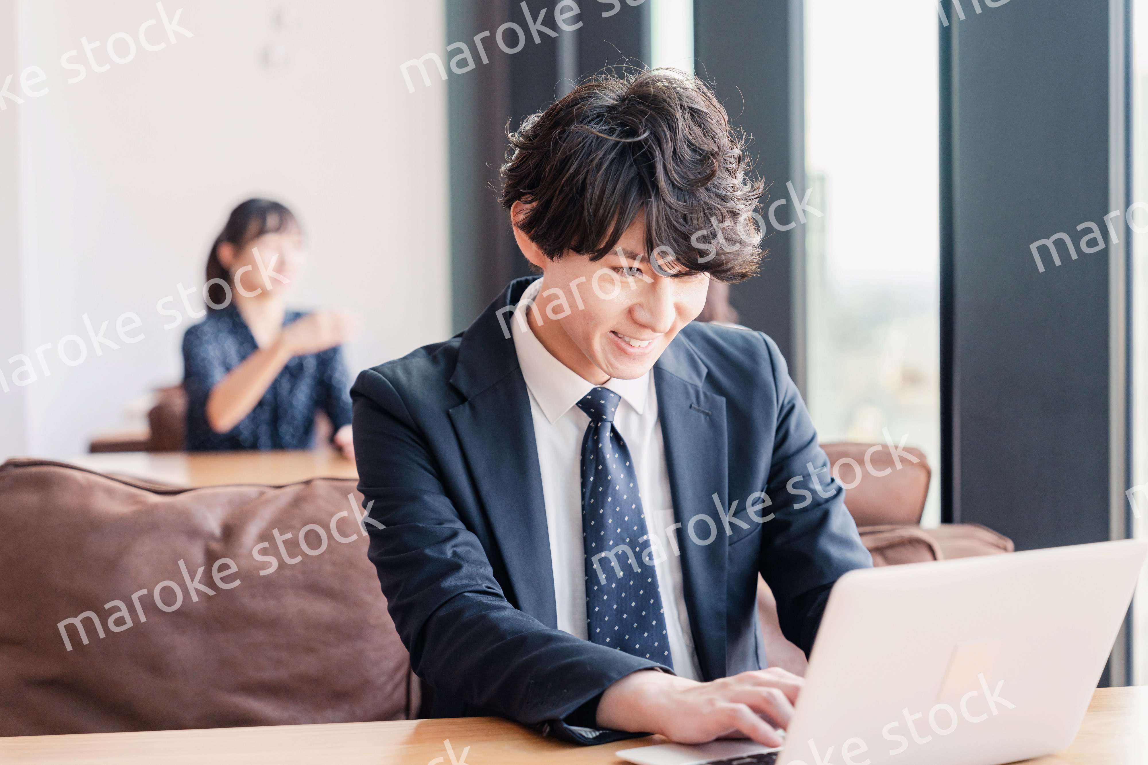 オフィスで笑顔で働くビジネスマン