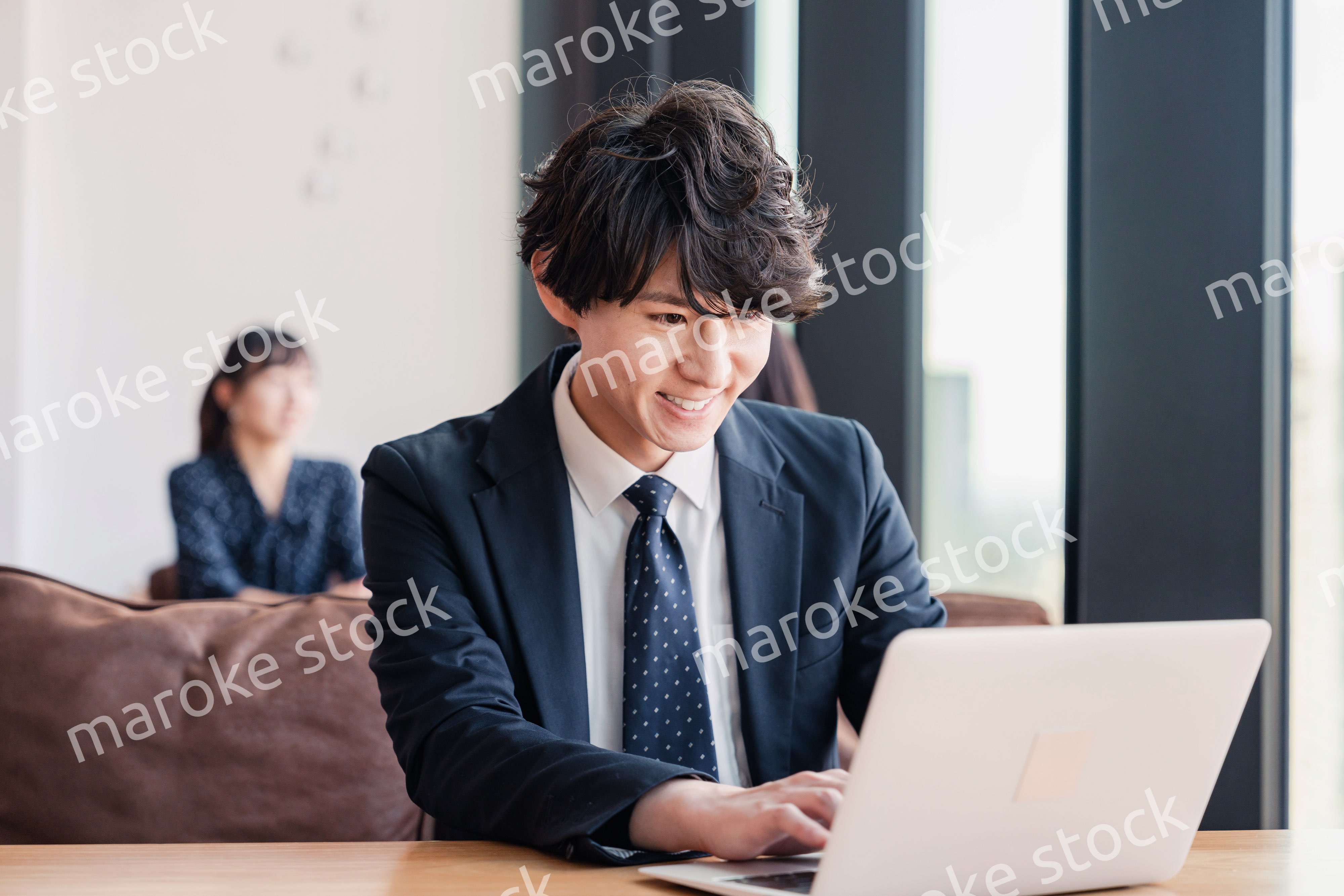 オフィスで笑顔で働くビジネスマン