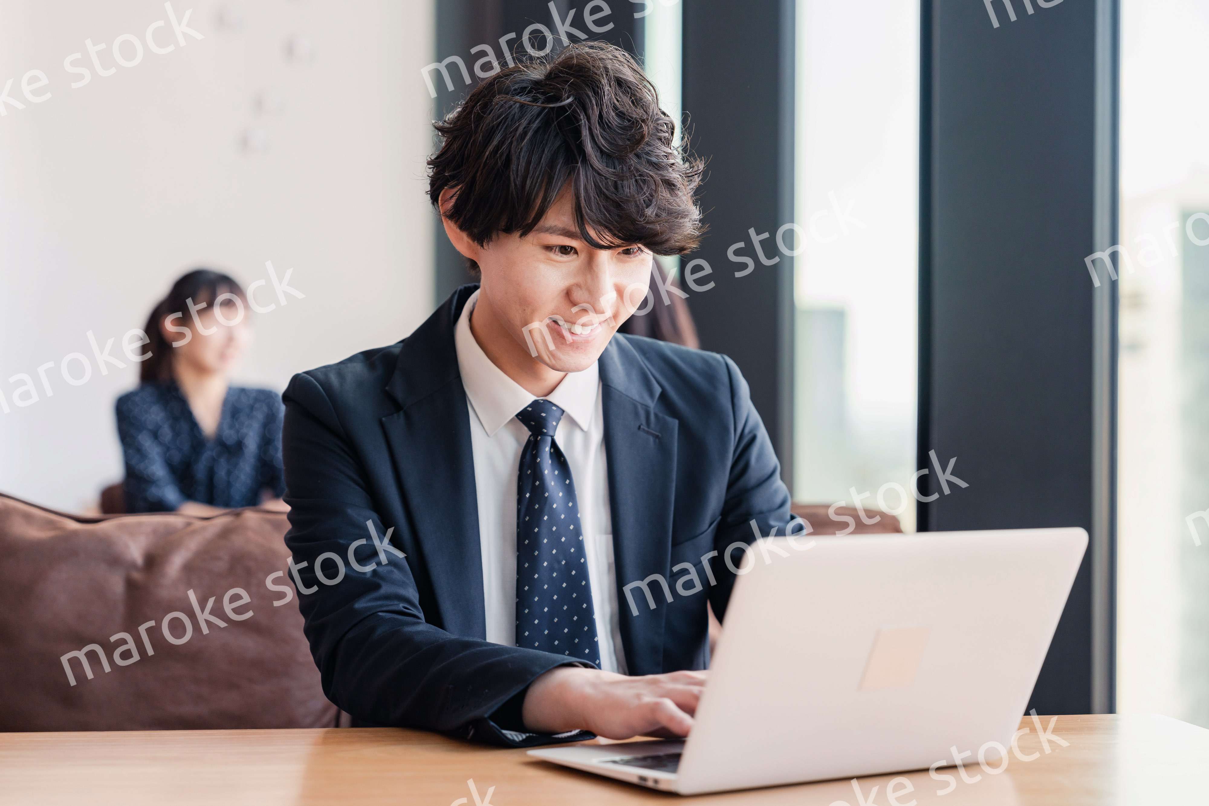 オフィスで笑顔で働くビジネスマン