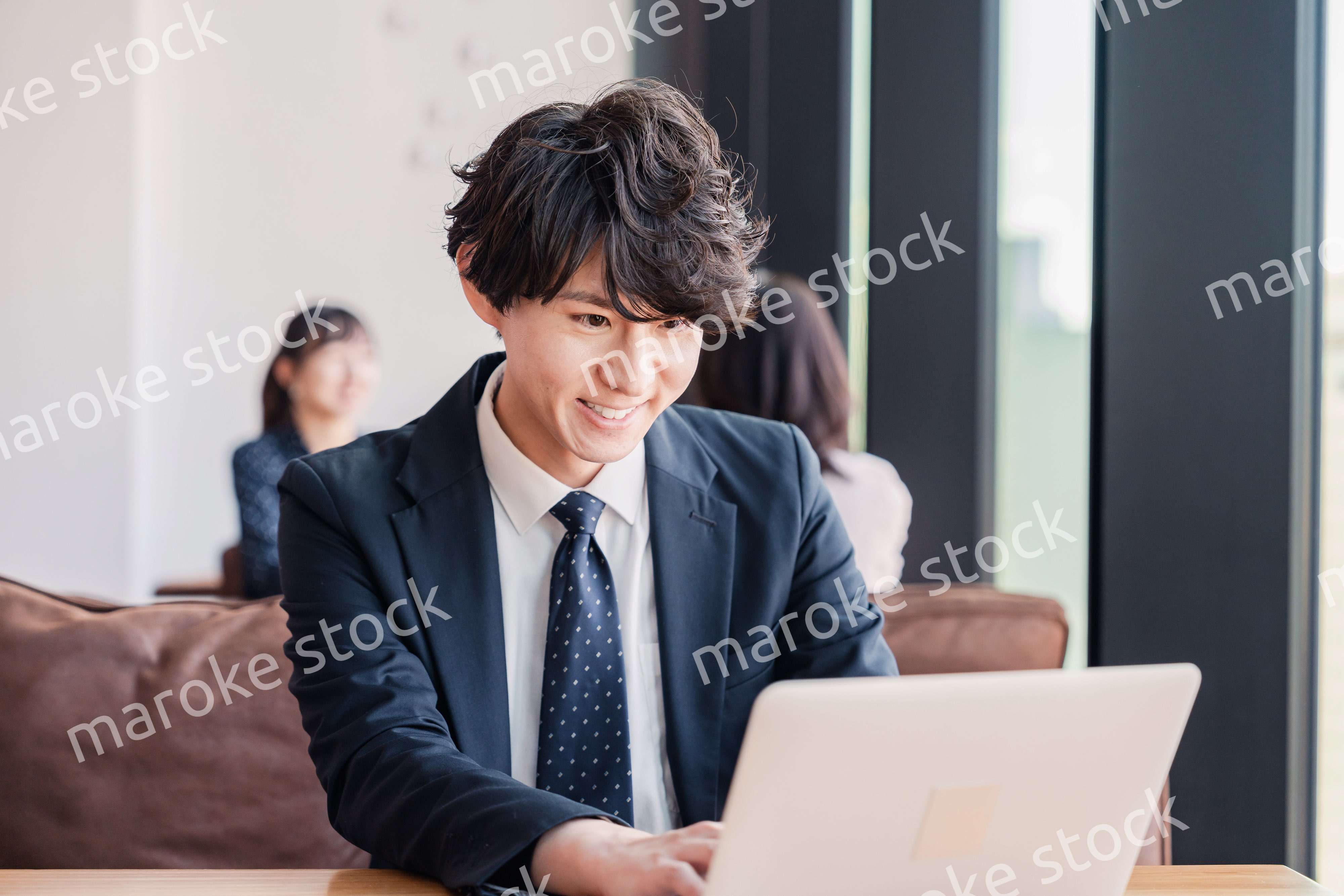 オフィスで笑顔で働くビジネスマン