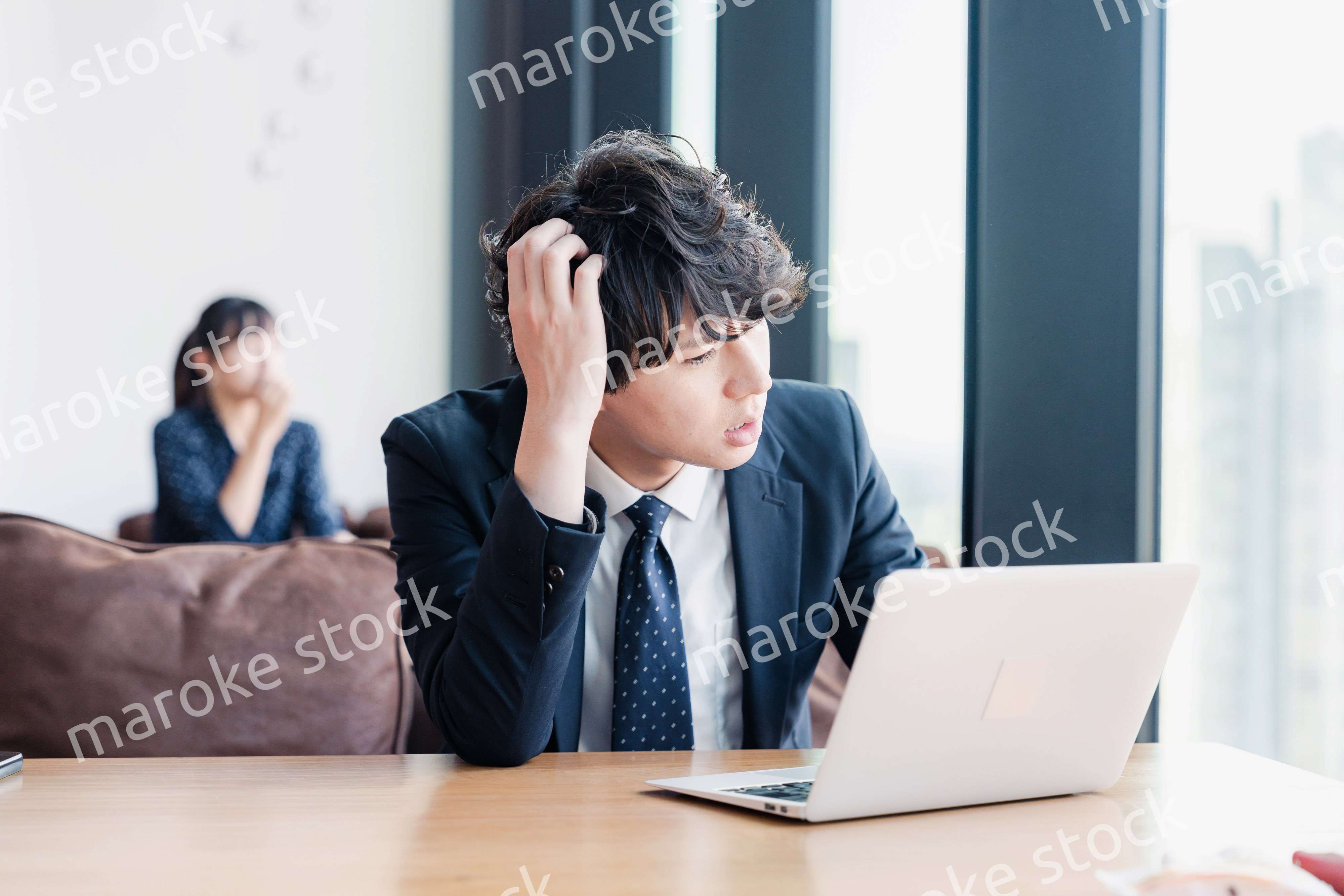 オフィスで頭を抱えるビジネスマン