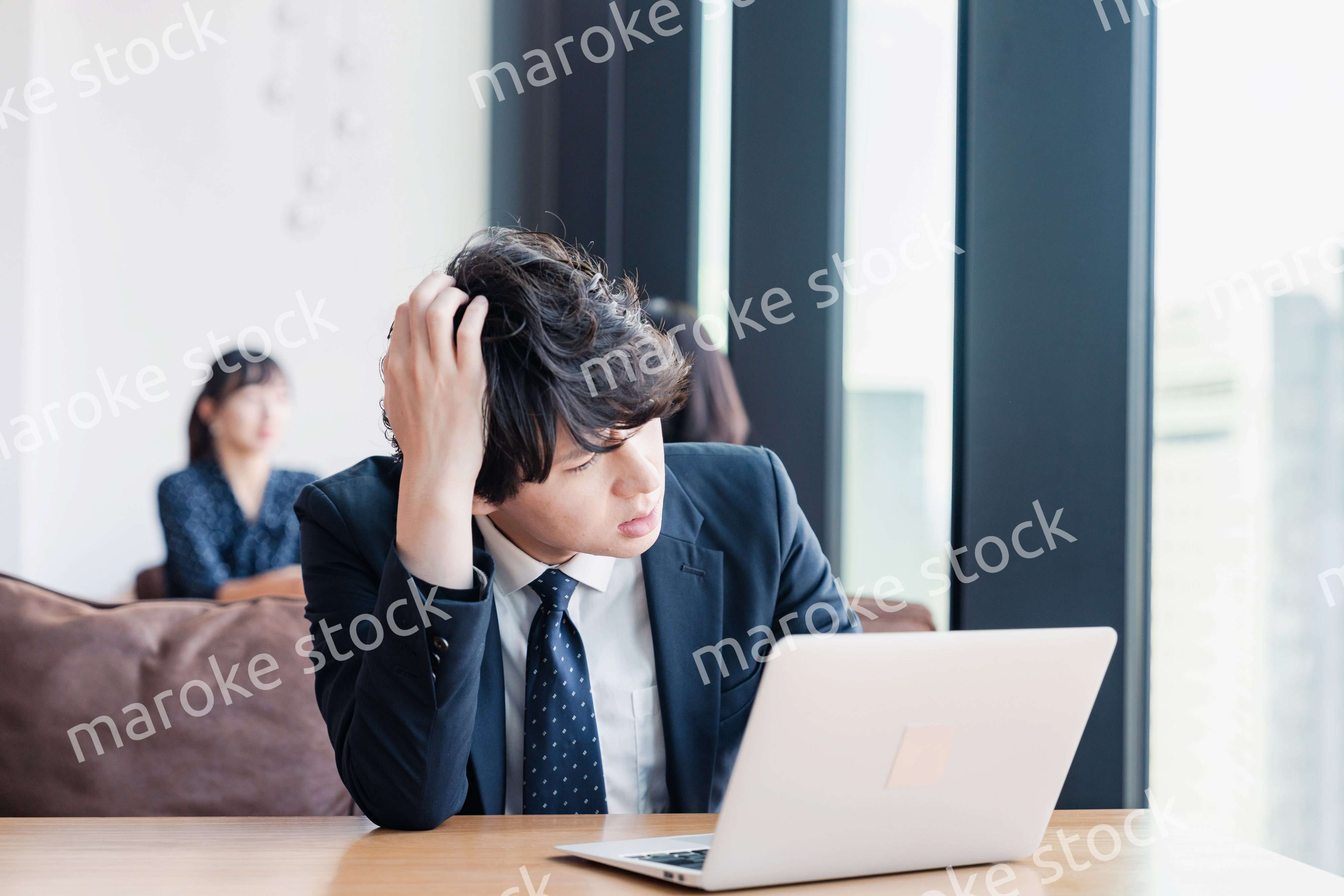 オフィスで頭を抱えるビジネスマン