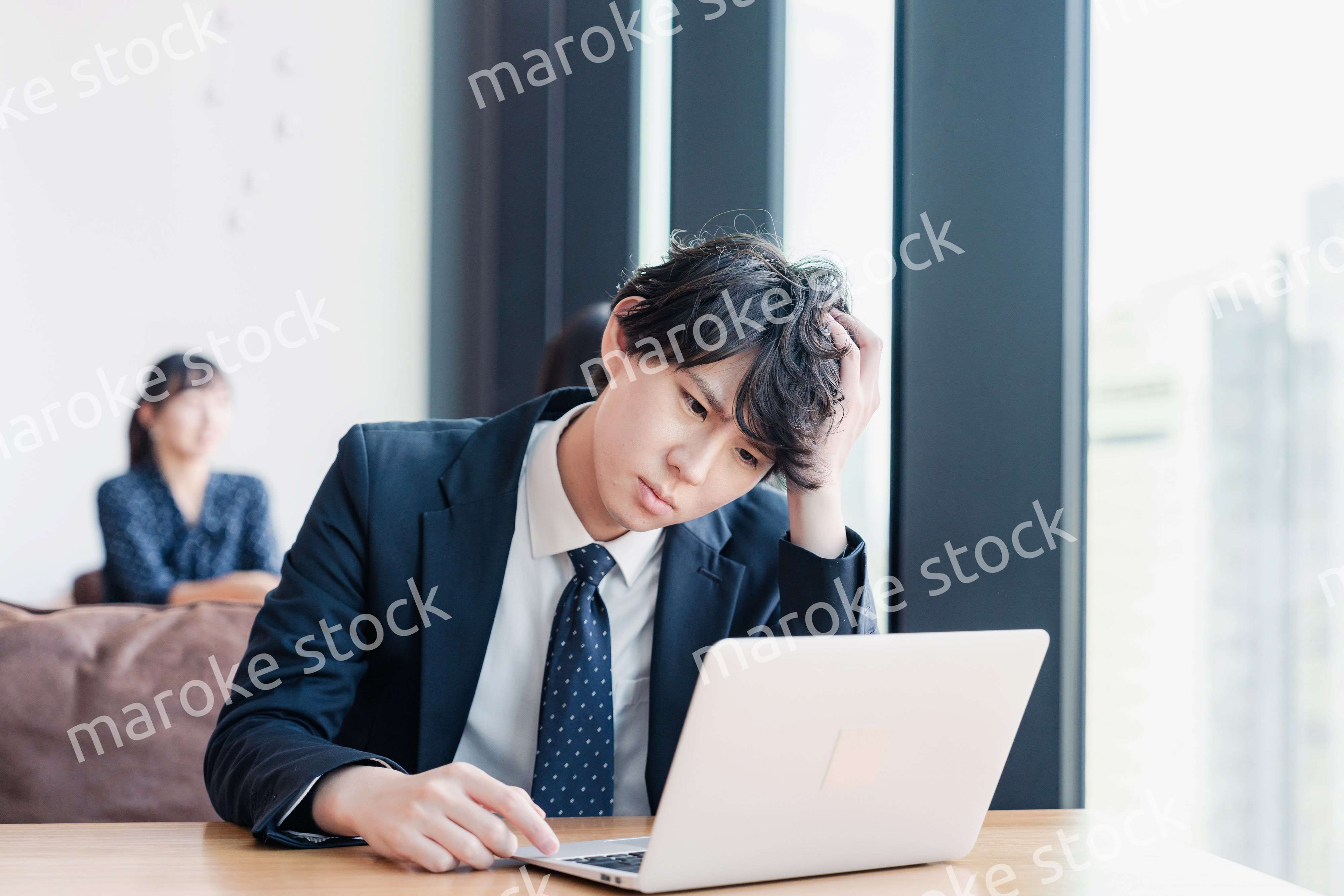 オフィスで頭を抱えるビジネスマン