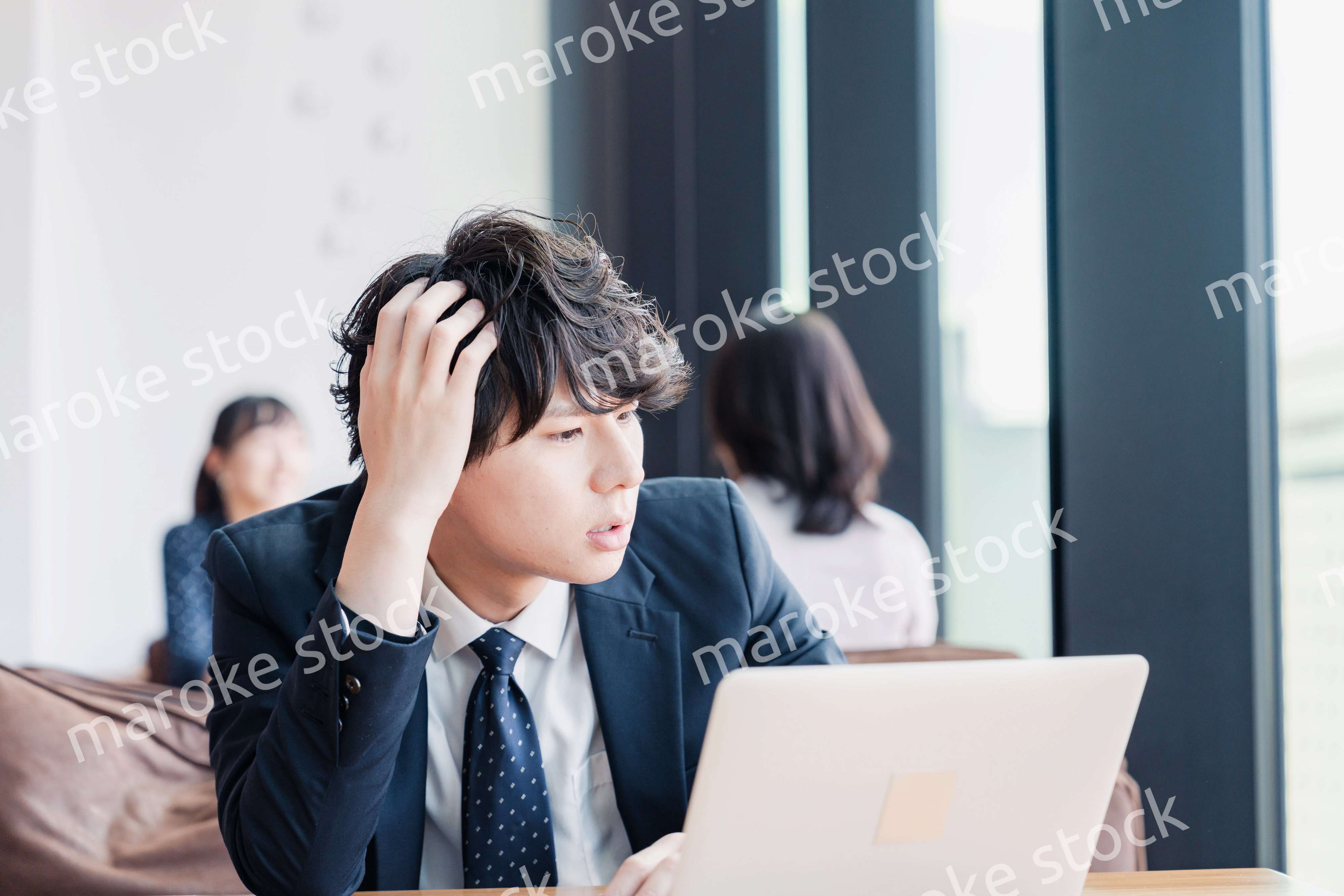 オフィスで頭を抱えるビジネスマン