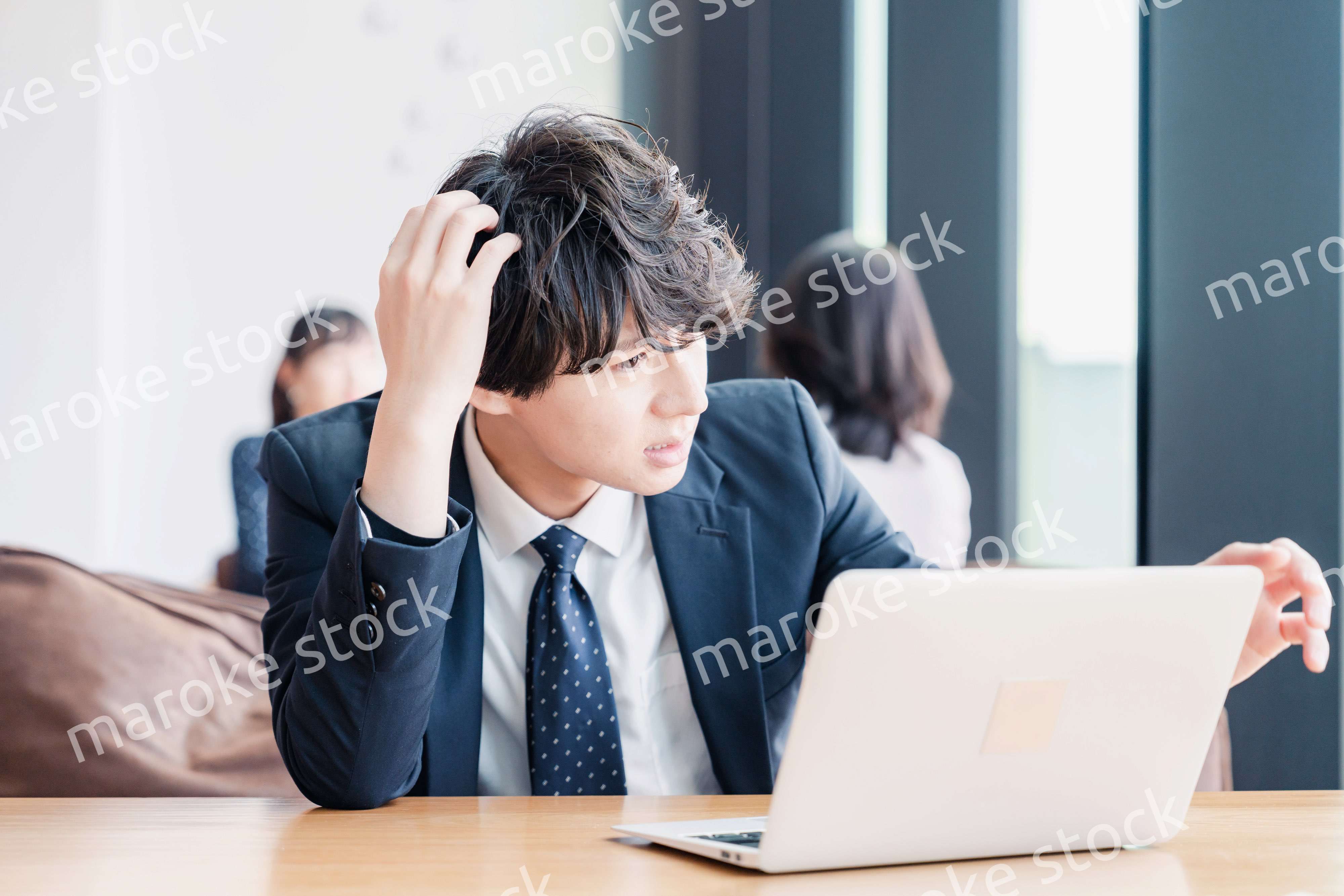 オフィスで頭を抱えるビジネスマン
