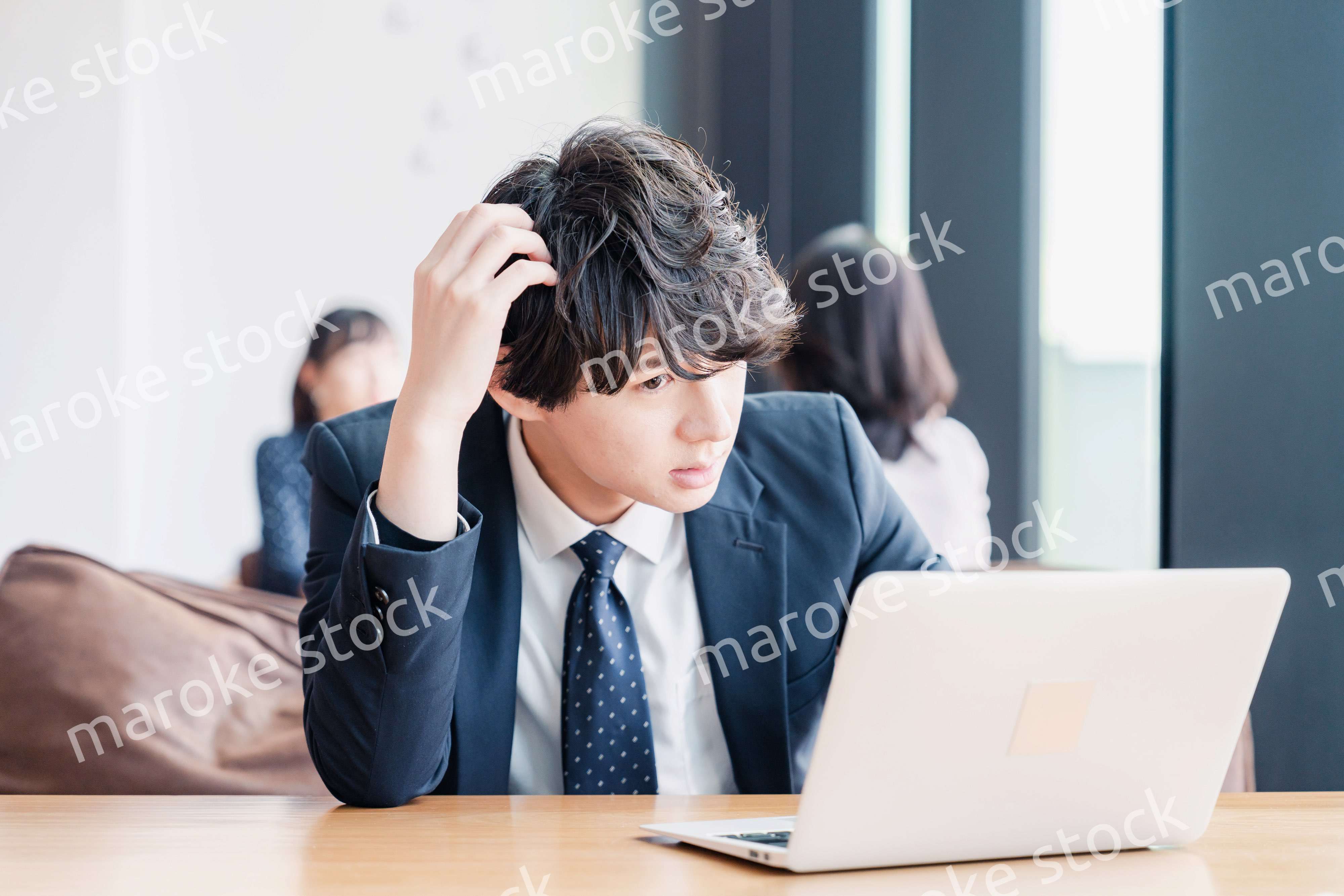 オフィスで頭を抱えるビジネスマン