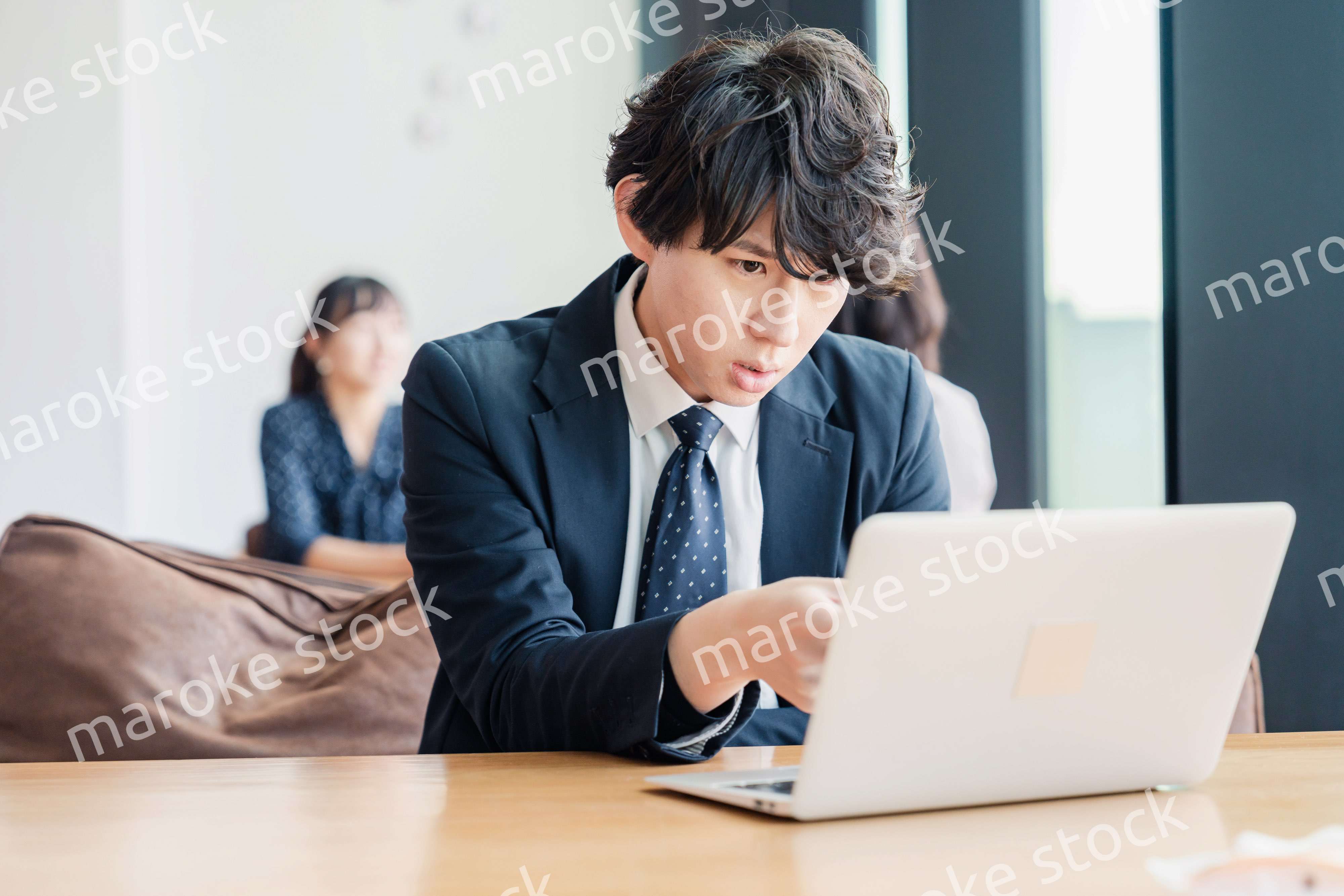 オフィスでパソコンと格闘するビジネスマン