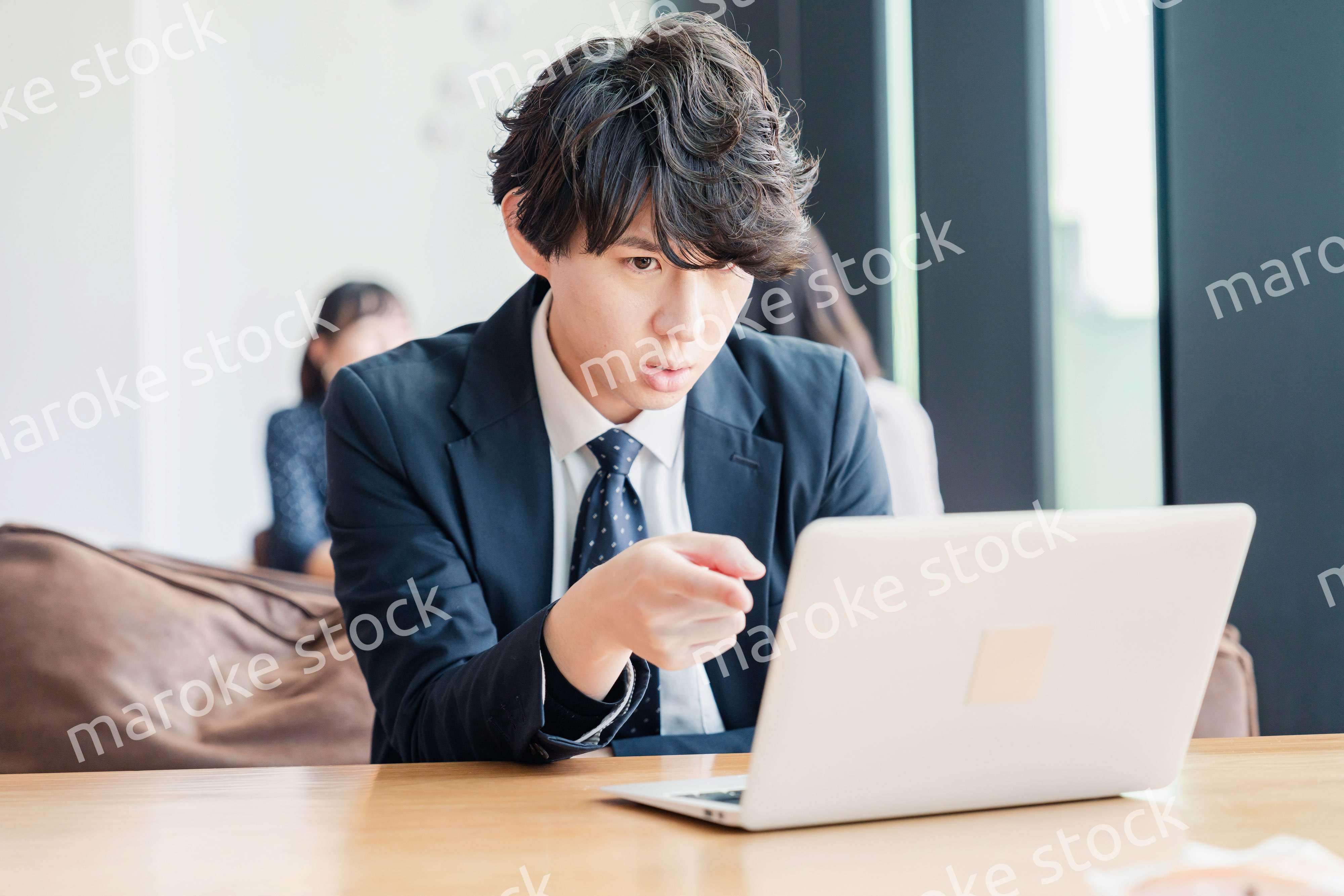 オフィスでパソコンと格闘するビジネスマン